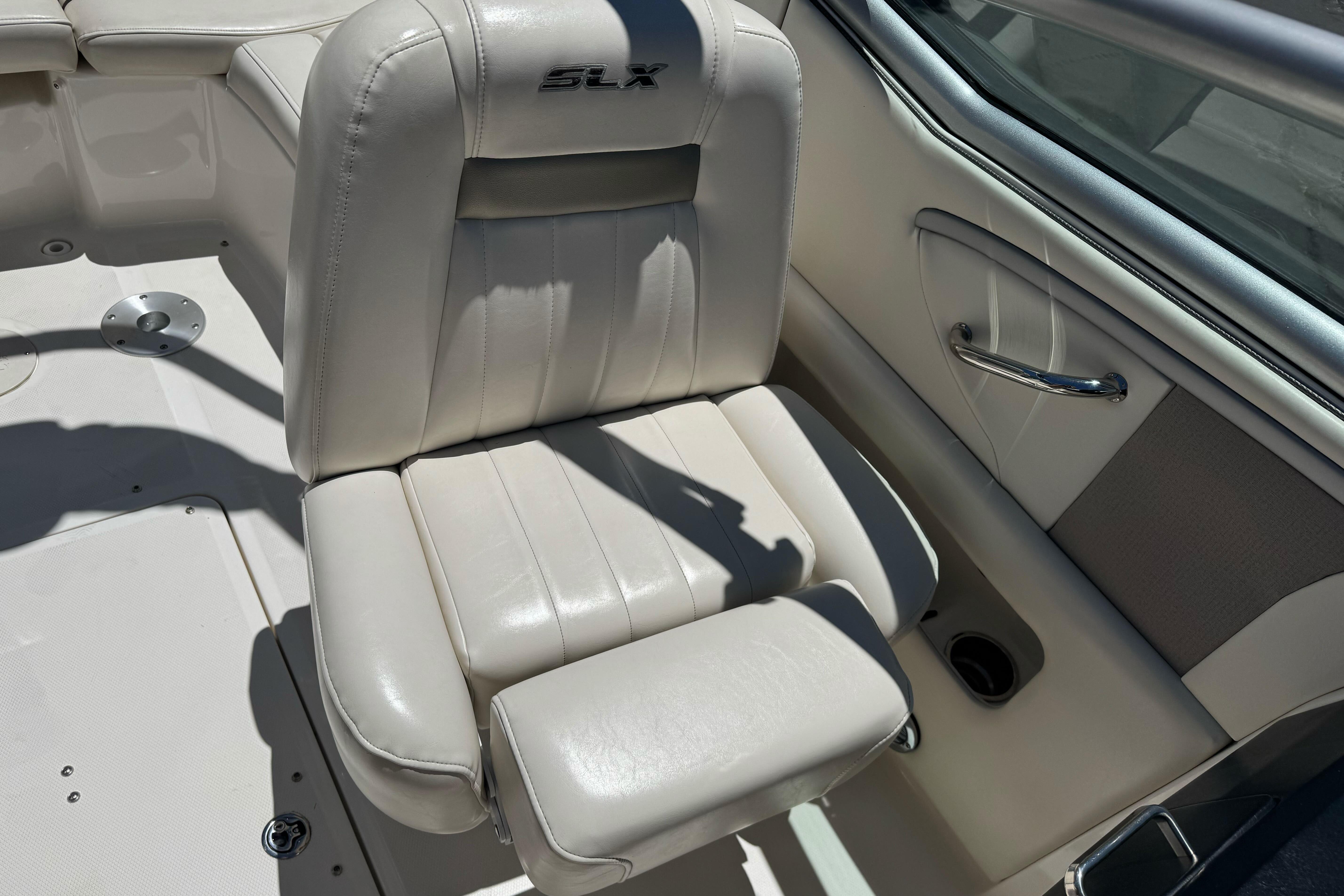 2007 Sea Ray SLX 250 boat seat with beige upholstery and armrest.