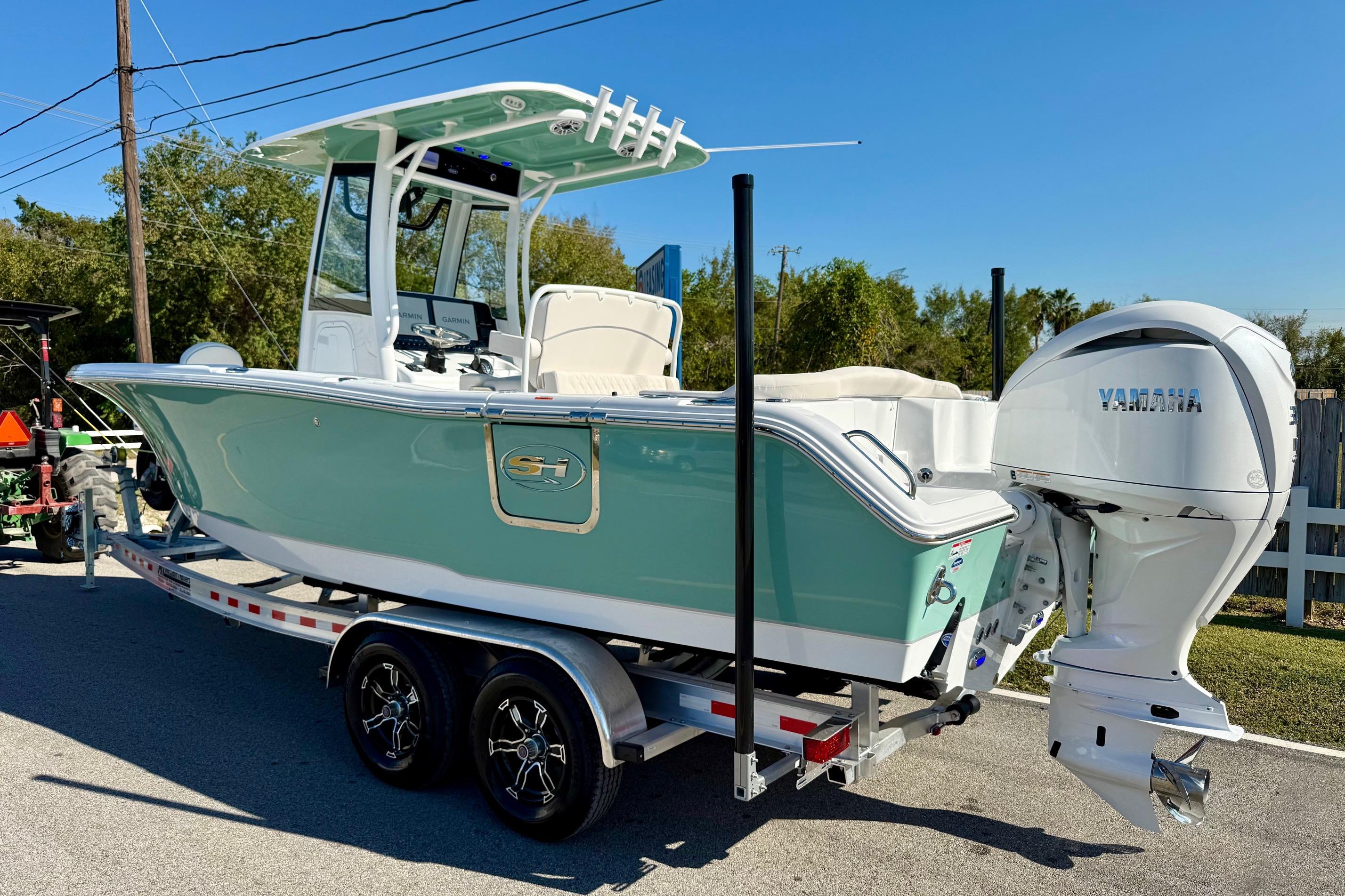 2026 Sea Hunt Ultra 255 SE boat on trailer with Yamaha engine, parked outdoors.