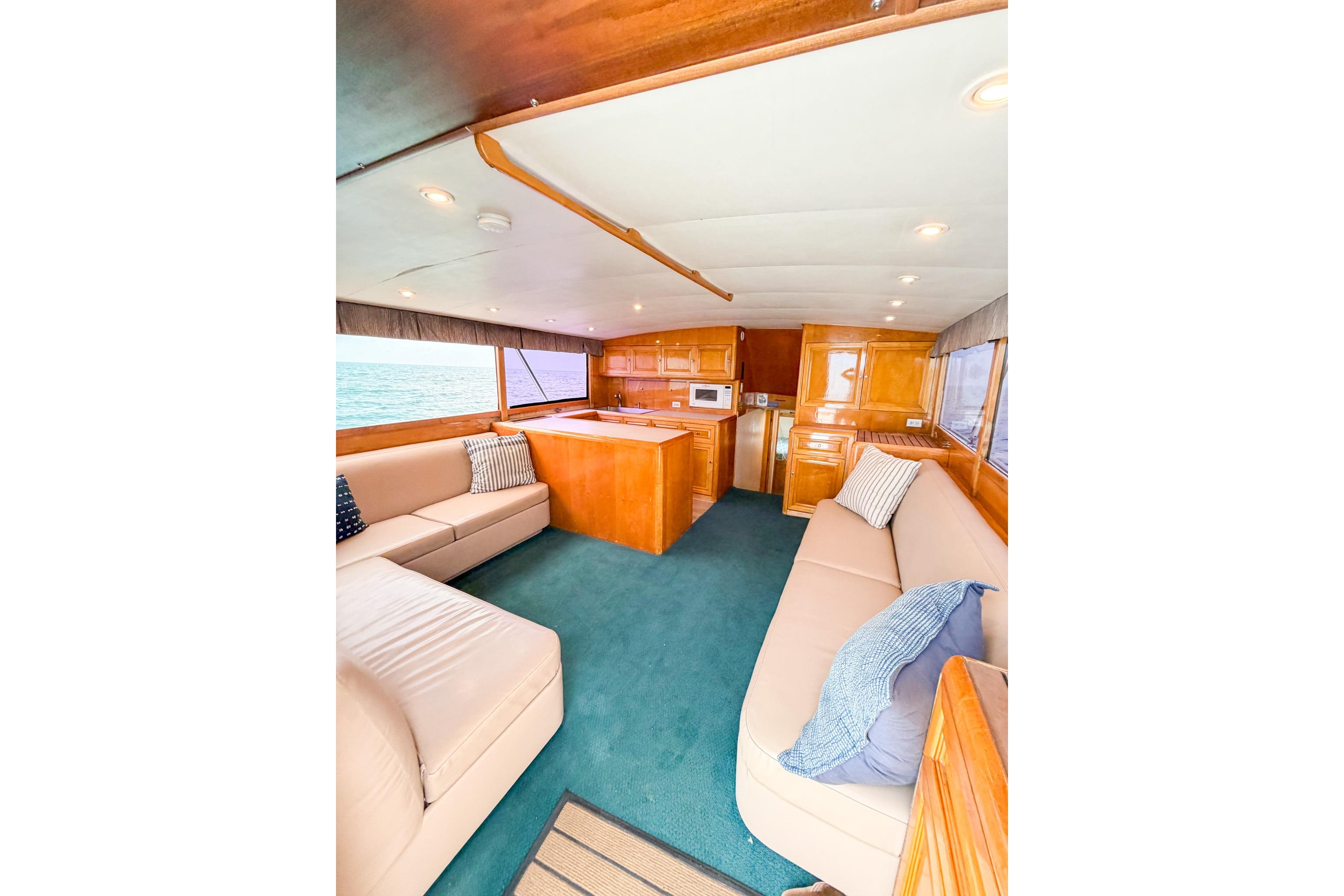 Luxurious interior of 1998 Blackwell Custom Carolina Sportfish yacht with plush seating and wood finishes.