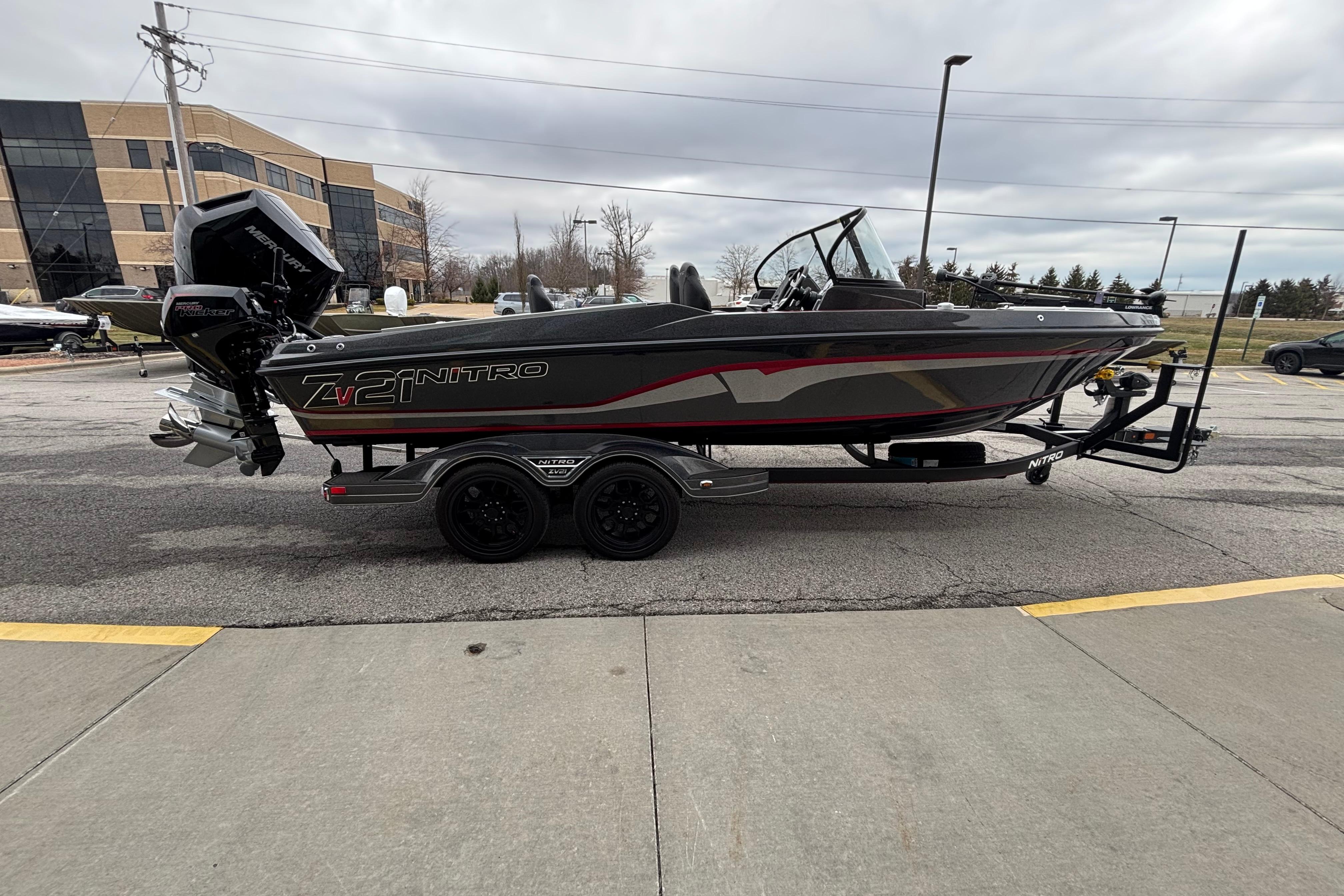 2024 Nitro ZV21 Pro boat on trailer, parked outdoors near office buildings.