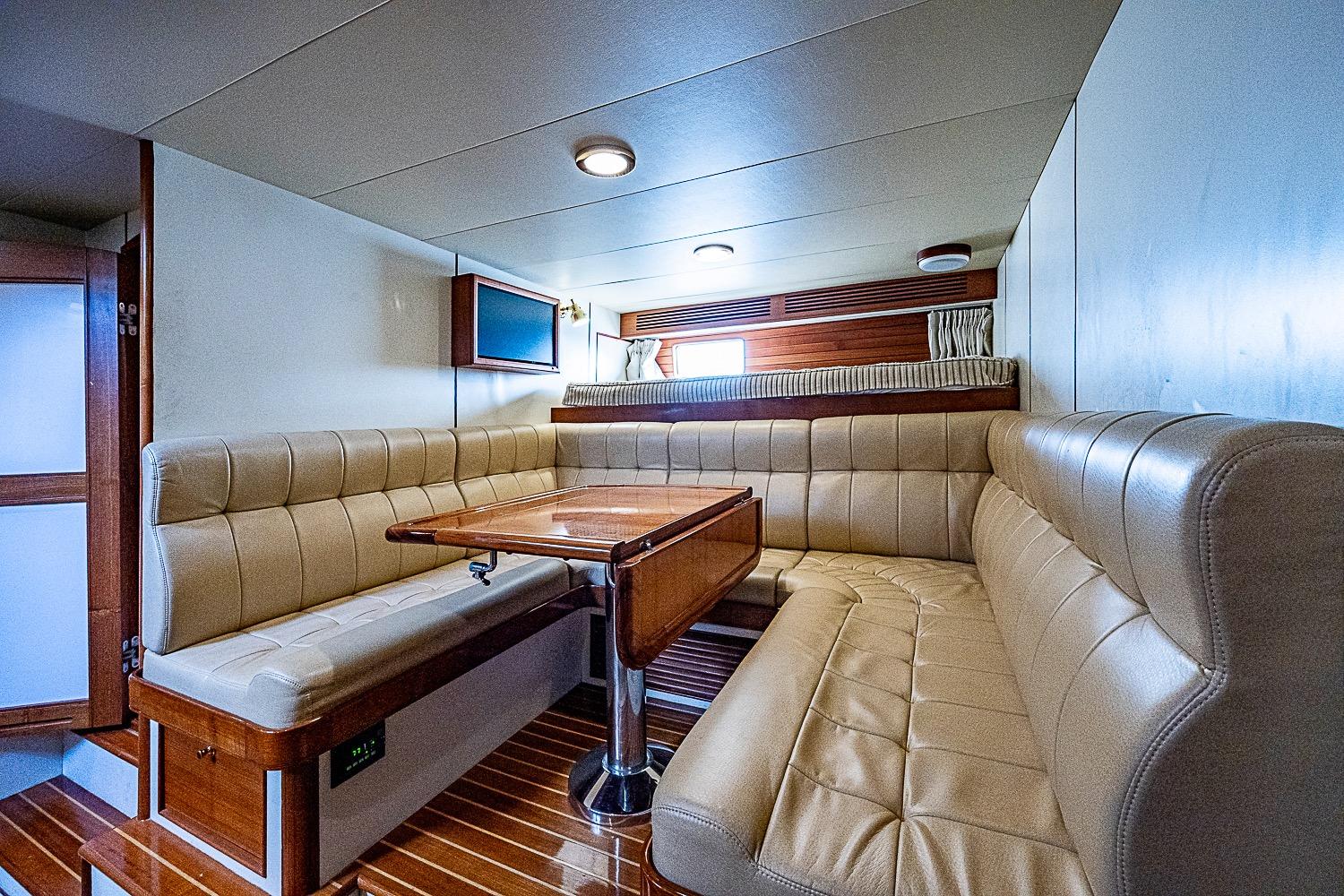 Luxurious interior of 2014 Marlow 80 Explorer yacht with plush seating and wooden table.