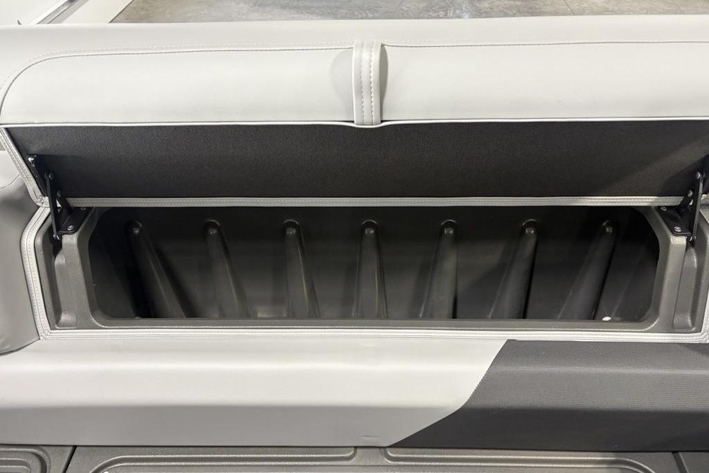 2026 Sun Tracker PARTY BARGE® 20 DLX storage compartment with open lid, showcasing interior space.