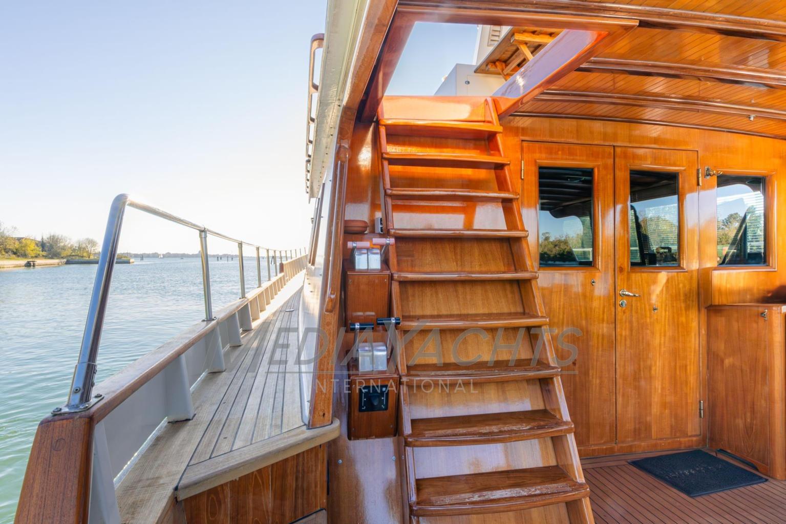Wooden interior of 2000 Cantiere Nautico Azzurro 20 yacht with stairs and water view.