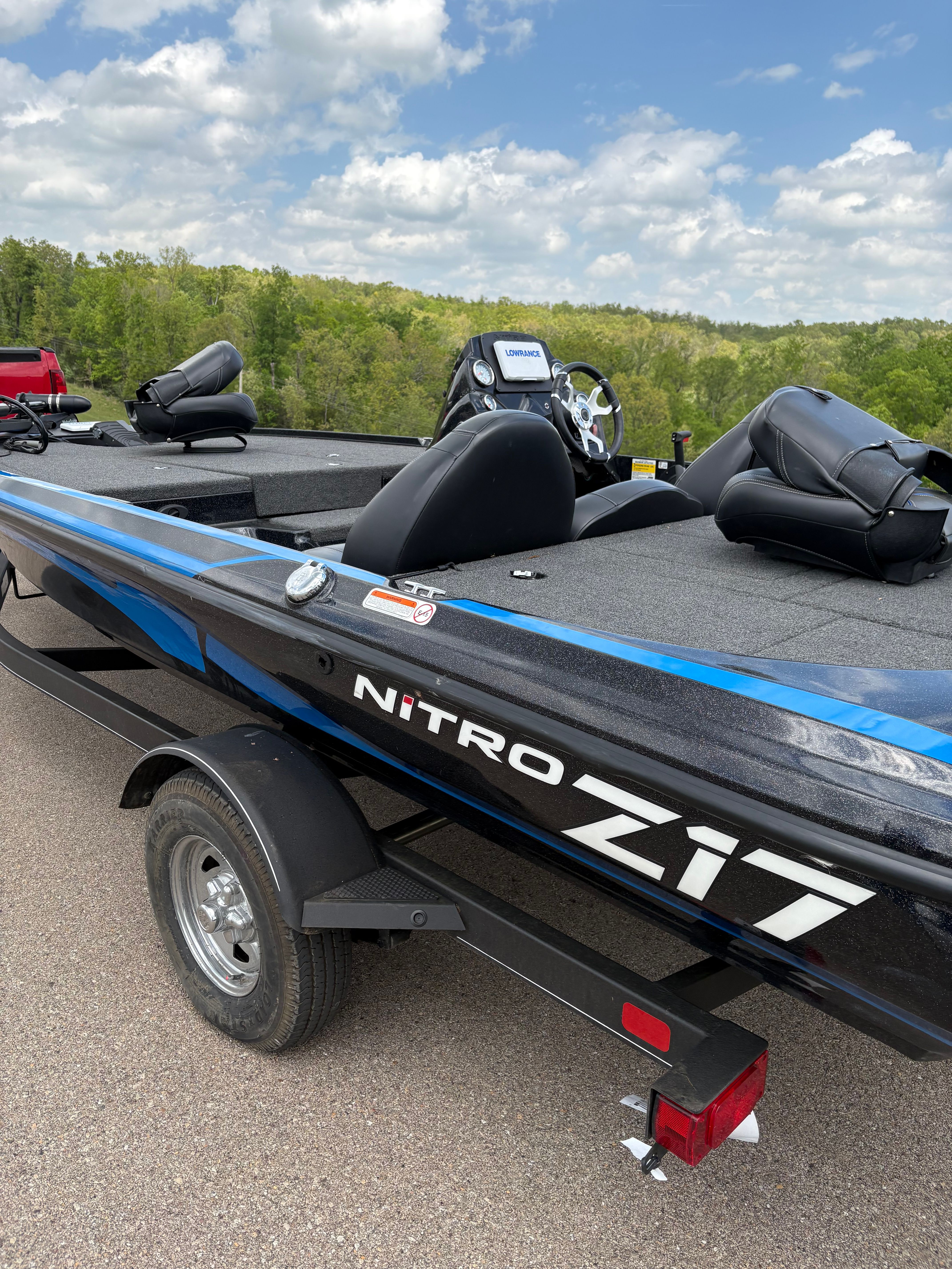 2022 Nitro Z17 boat on trailer, blue sky, green trees.