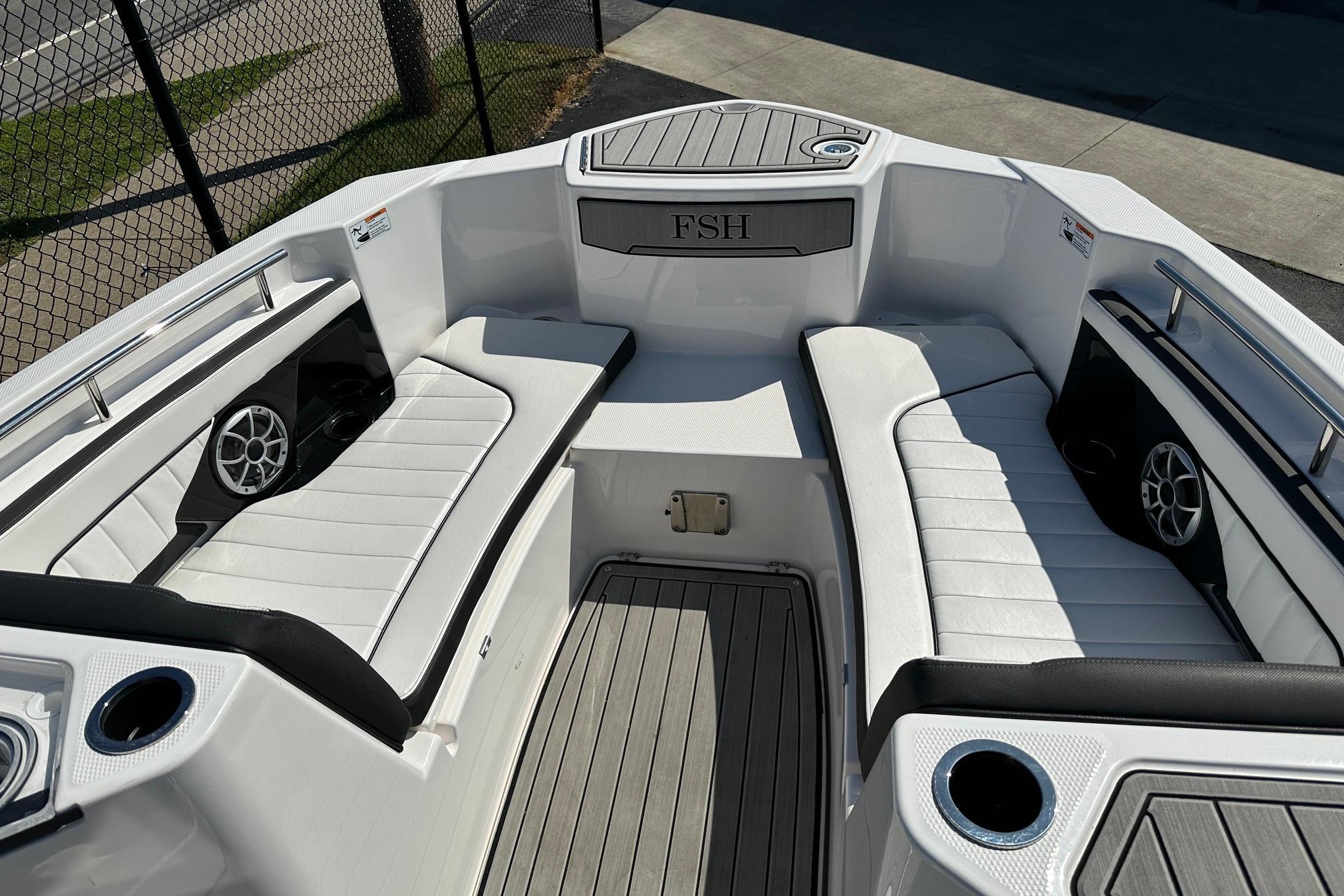 2022 Yamaha Boats 255 FSH Sport E interior with white seating and speakers.