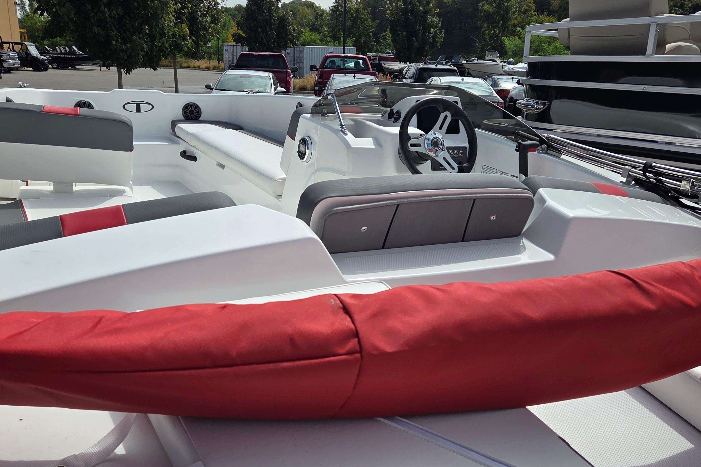 2026 Tahoe T18 boat interior with steering wheel and seating, parked outdoors.