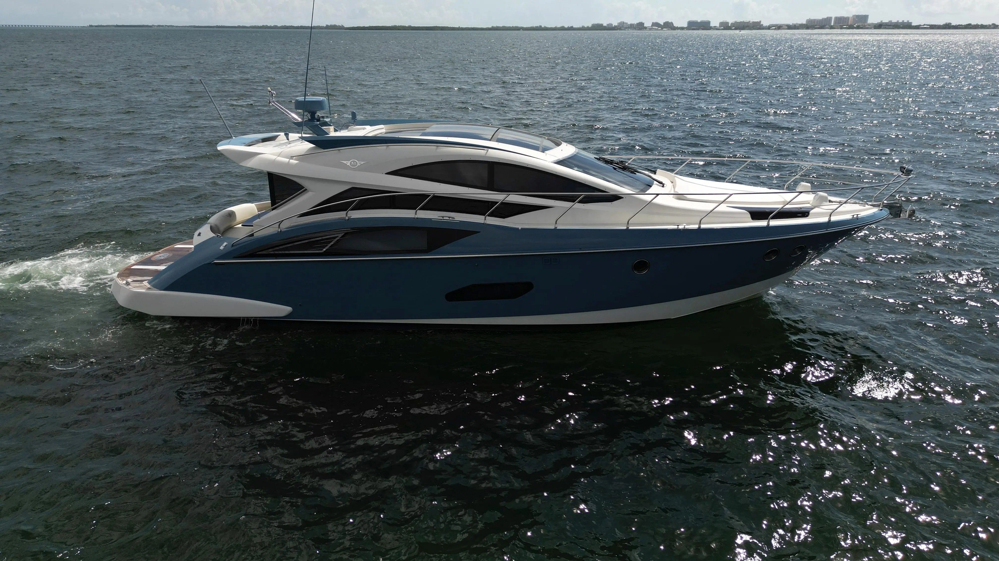 A 2010 Marquis Sport Coupe on the water, featuring sleek design and blue hull color.