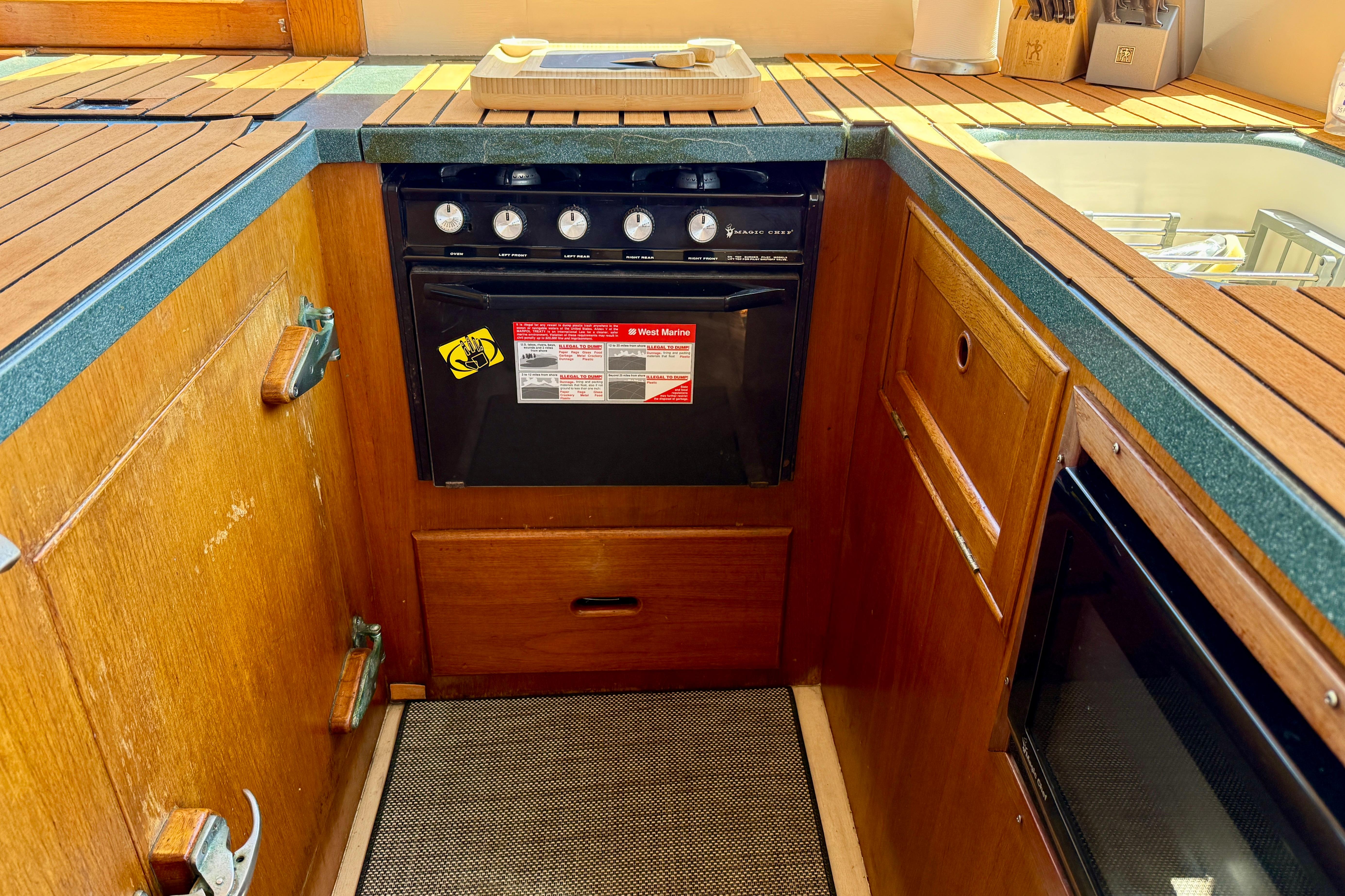 1991 Kong & Halvorsen Island Gypsy yacht kitchen with wooden cabinetry and stove.