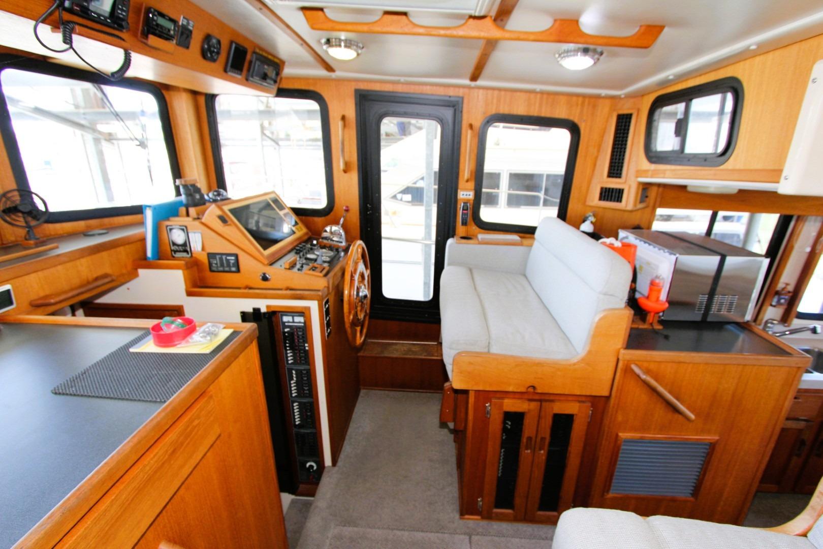 Interior of a 2002 Nordic Tug 37, featuring a cozy helm and seating area.