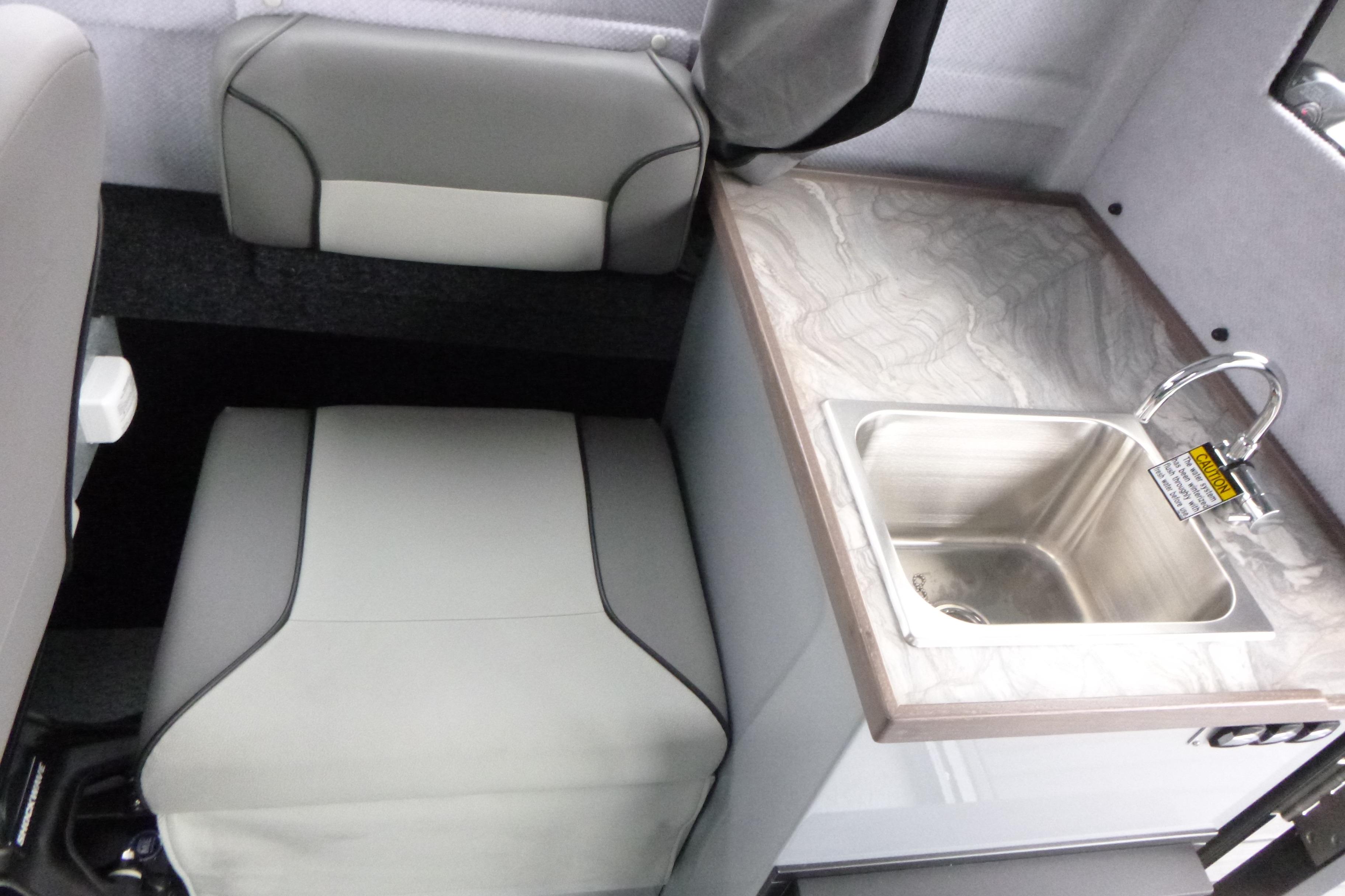 Interior of 2026 KingFisher 25 XAC boat with seating and compact sink.
