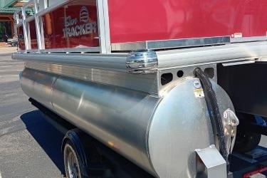 2026 Sun Tracker Bass Buggy 16 XL Select pontoon boat, red exterior, on trailer.