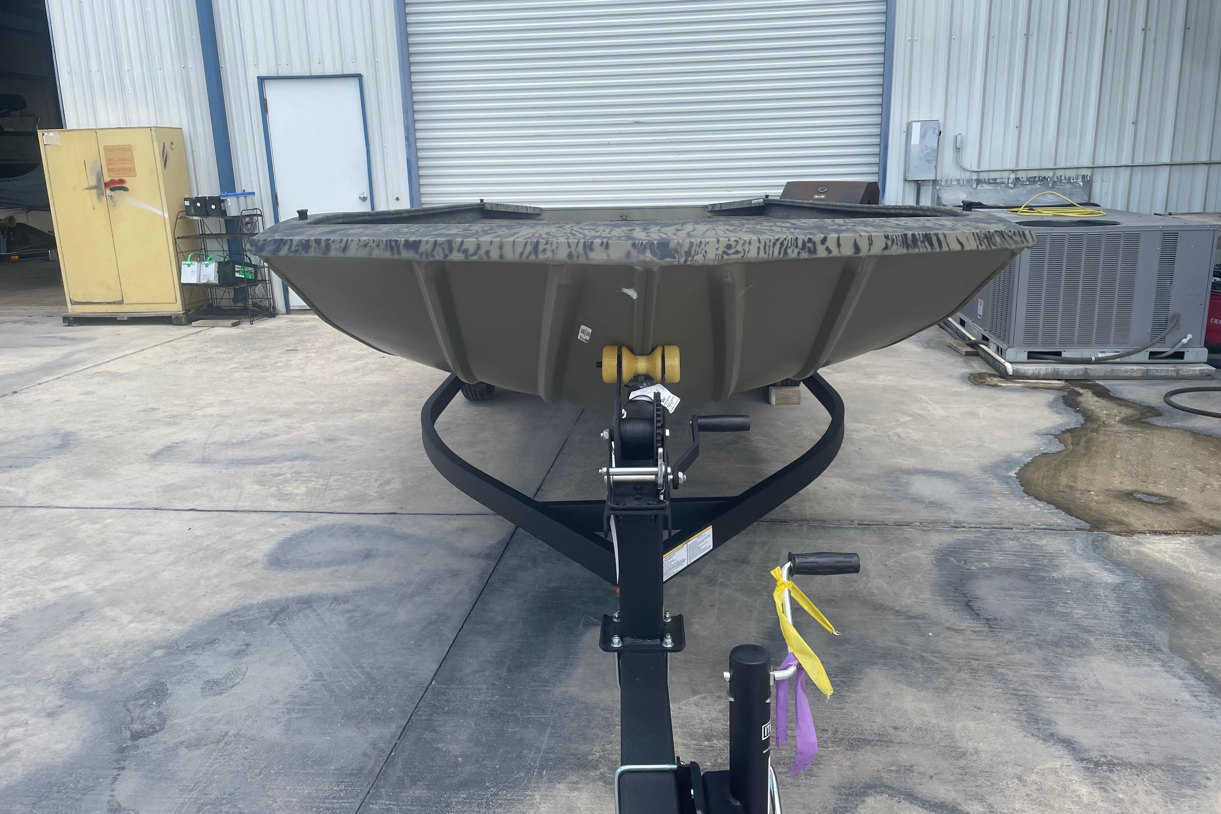 2026 Tracker Grizzly 1860 Utility boat on trailer in industrial setting.