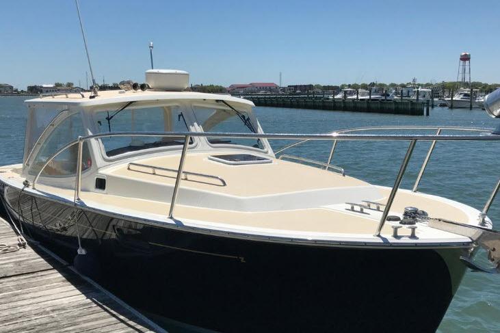 2009 MJM 29z Express boat docked at a marina on a sunny day.