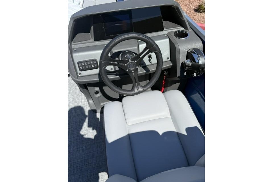 2026 Sun Tracker Party Barge 24 XP3 helm with steering wheel and control panel.