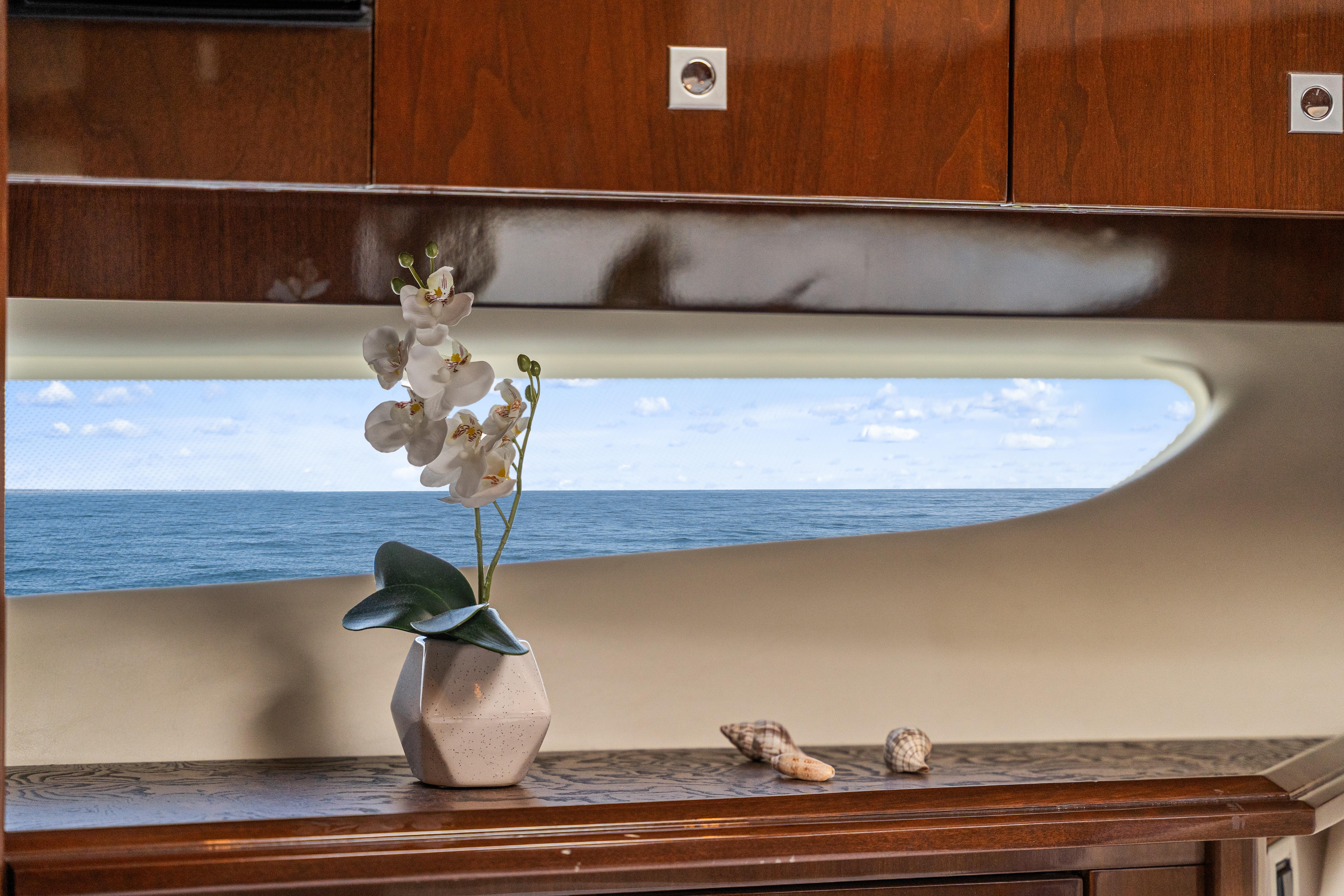 Luxurious 2007 Marquis 55 LS yacht interior with ocean view, featuring elegant decor and wooden cabinetry.