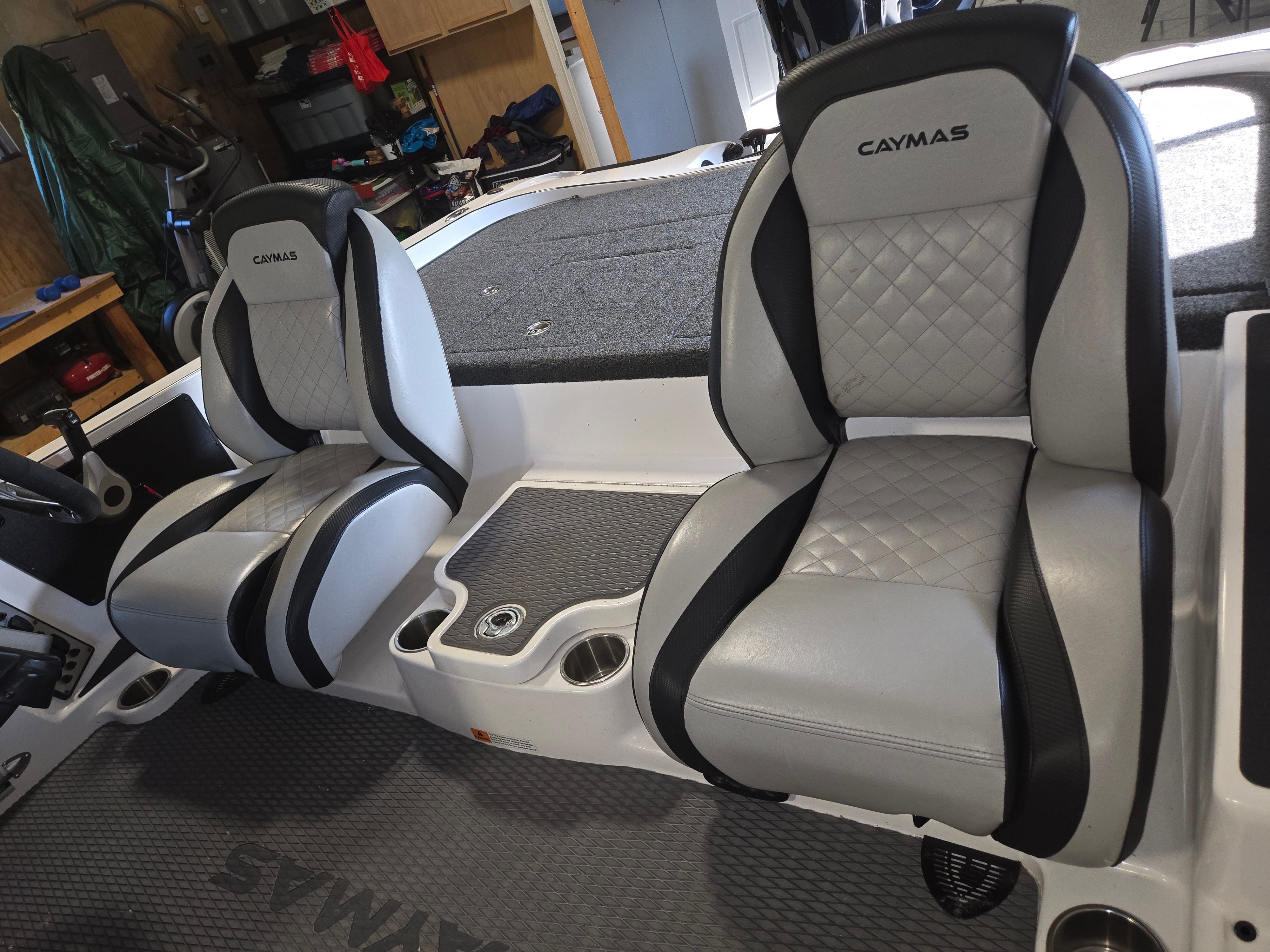 Two cushioned seats in a Caymas CX 19 boat, featuring gray and black accents.