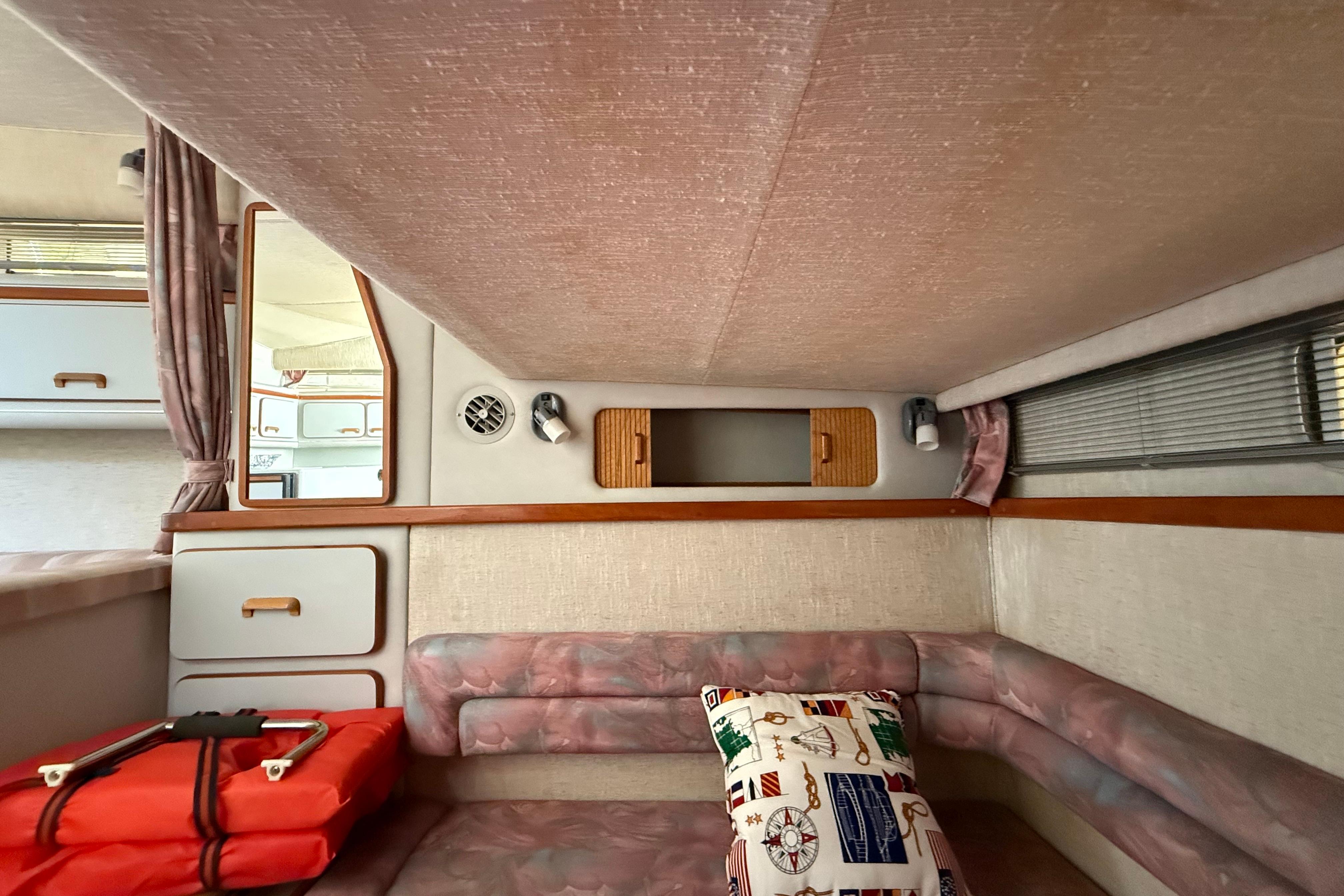 1990 Sea Ray 310 Express Cruiser cabin interior with seating, storage, and nautical-themed decor.