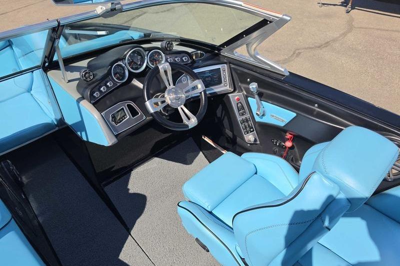 2017 MasterCraft X23 boat interior with blue seating and modern dashboard controls.