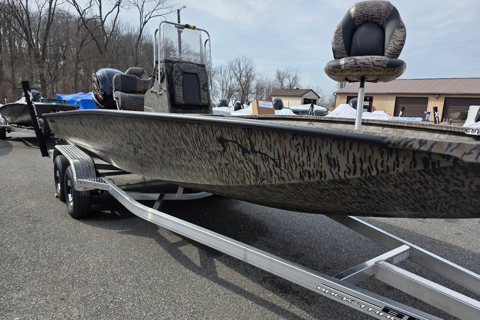 2026 Xpress H22B Bay boat on trailer, featuring camouflage design and dual axles.