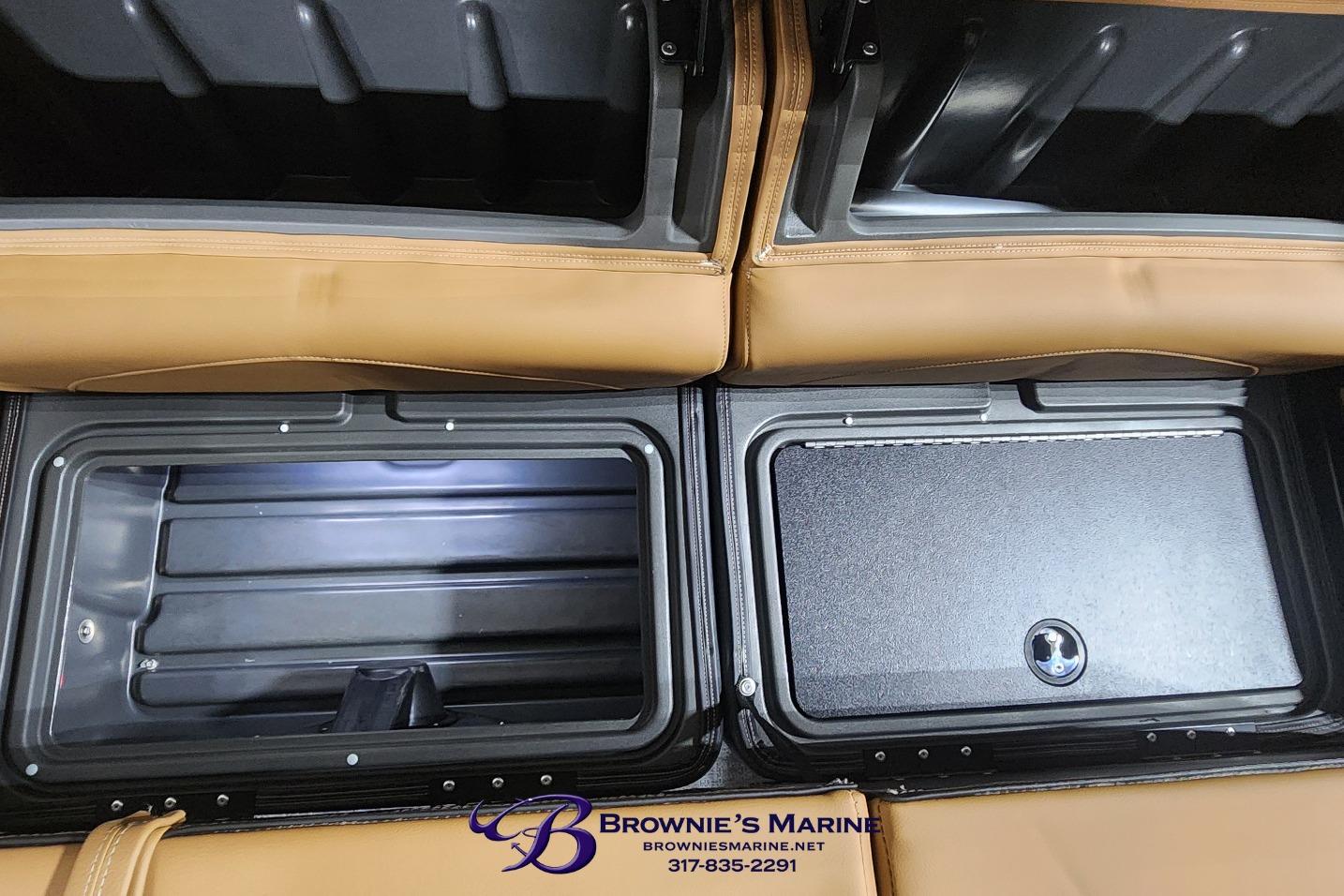 Interior storage compartments of a 2026 Regency 250 DL boat, featuring tan upholstery.