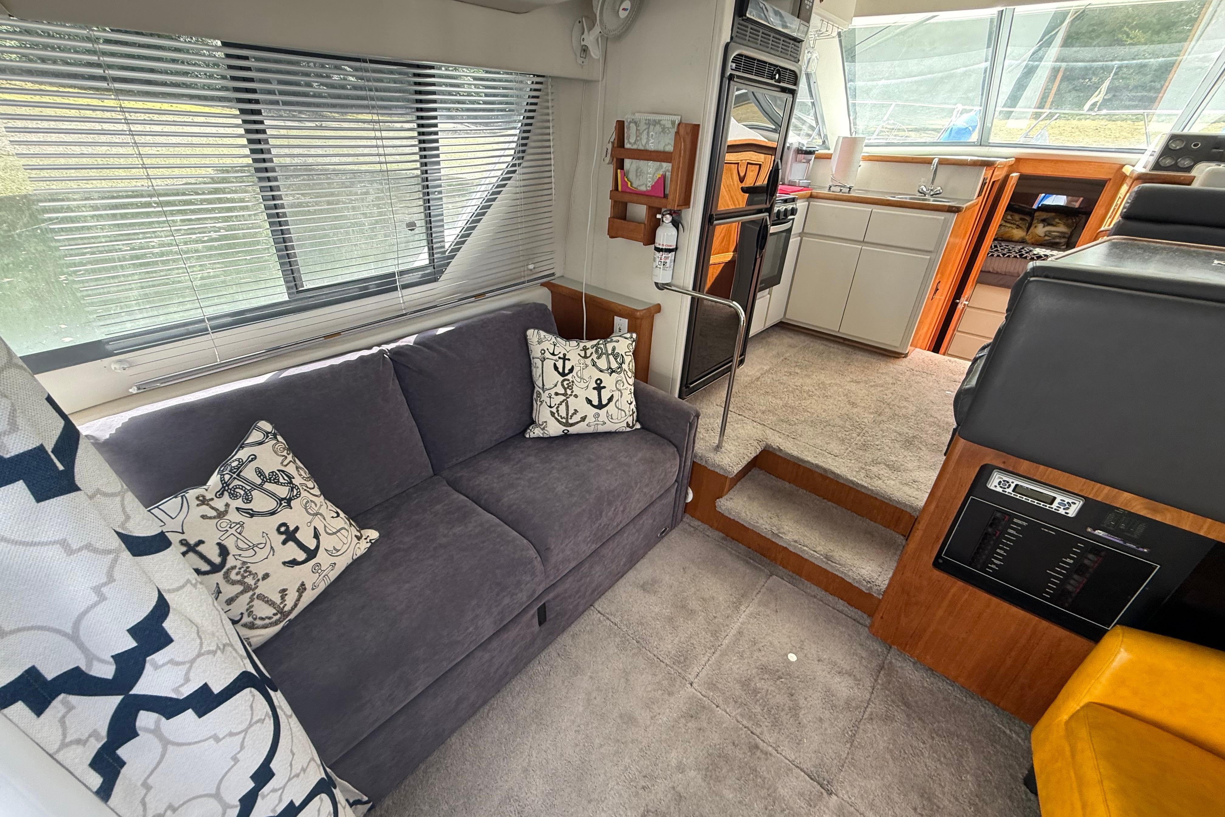 Interior of a 1995 Carver 370 Voyager yacht with cozy seating and nautical decor.