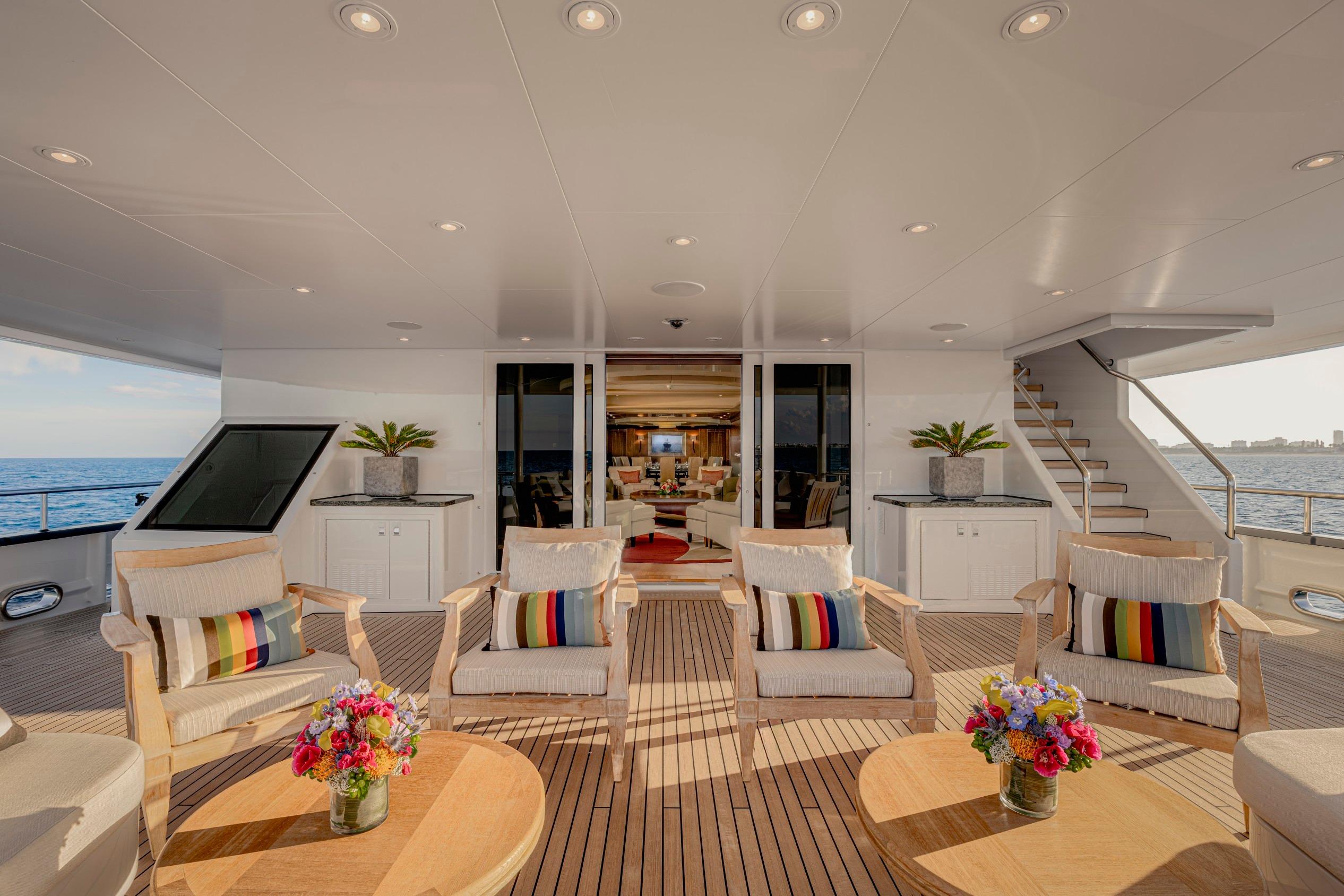 Luxurious yacht deck with seating, colorful cushions, and ocean view, Abeking & Rasmussen 2011 model.