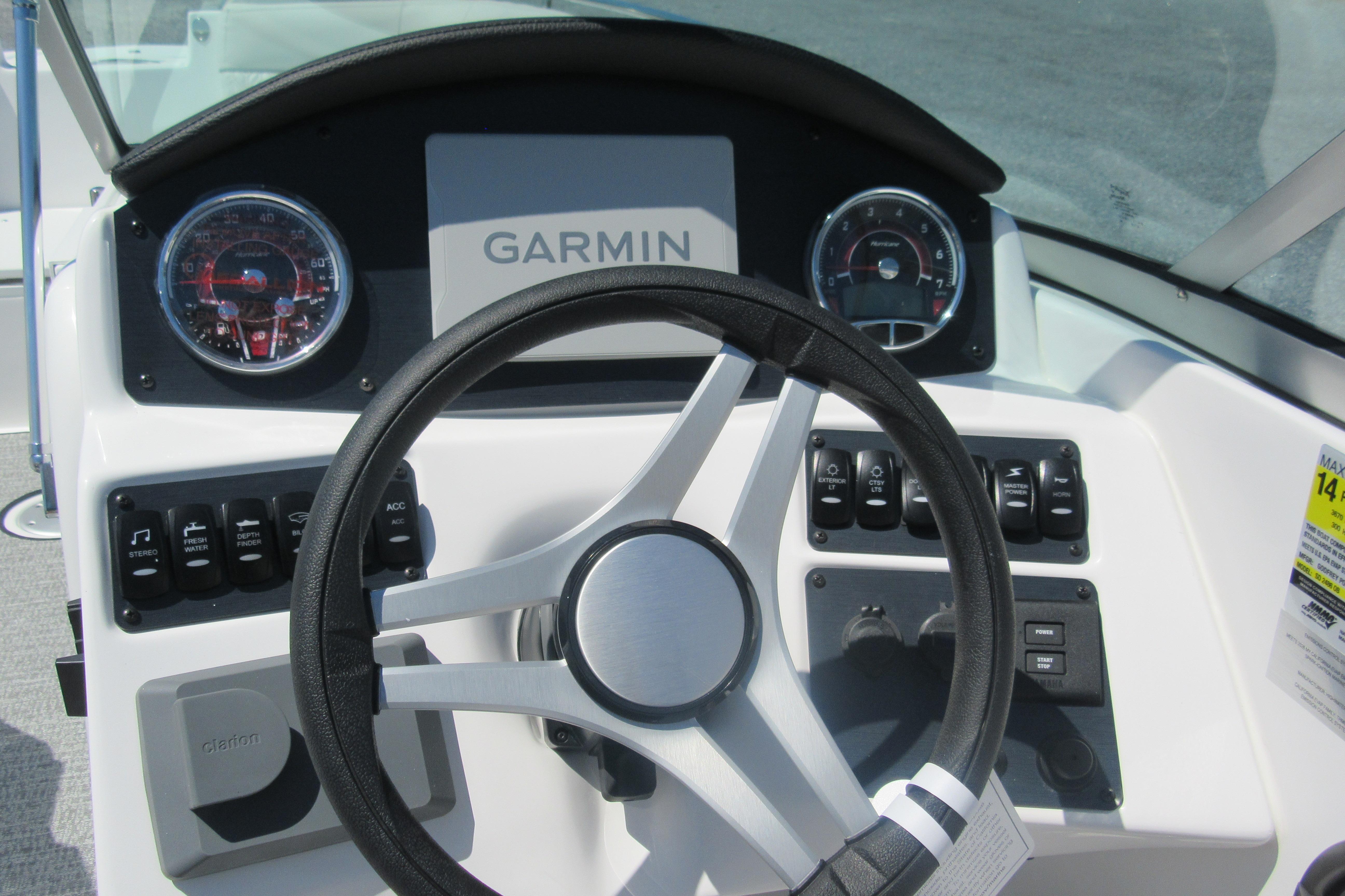 2027 Hurricane SunDeck 2486 OB boat dashboard with Garmin display and steering wheel.