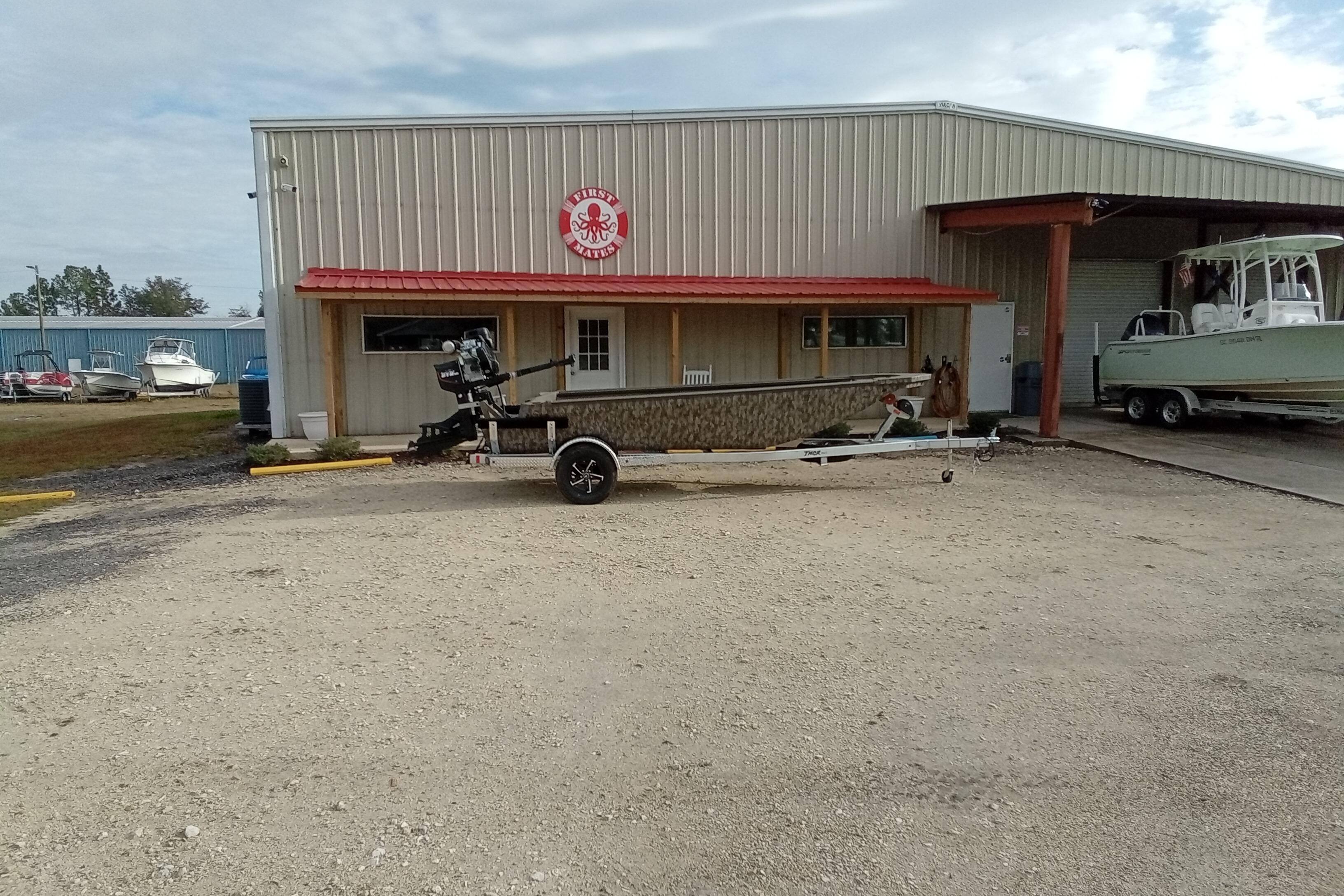 2026 Thor 1754 Swamp Hammer boat parked outside a metal building with red roof.