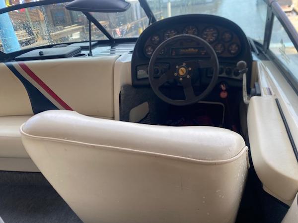 1998 Malibu Response boat interior with steering wheel and dashboard, featuring white and striped seating.