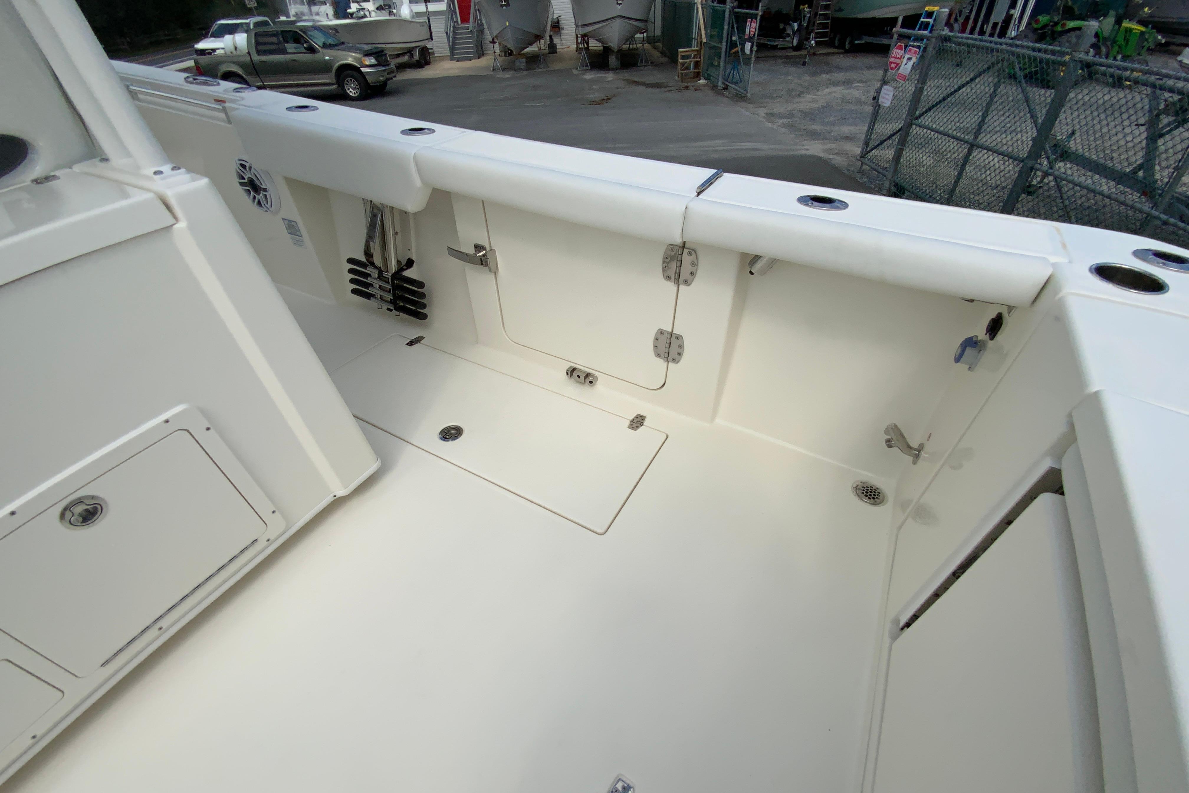 2027 Cobia 320 Center Console boat deck with storage compartments and rod holders.