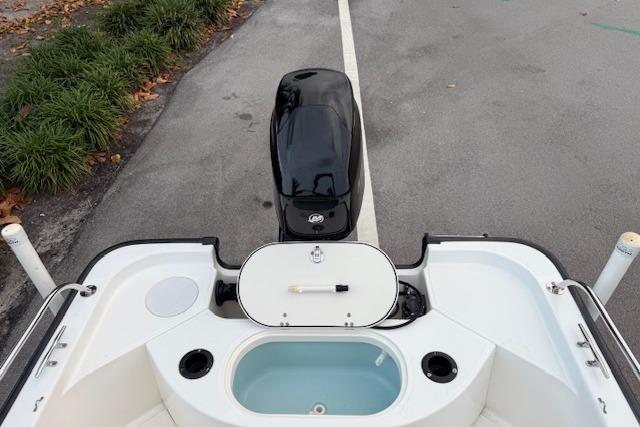 2016 Boston Whaler 150 Montauk boat stern view with motor and storage compartments.
