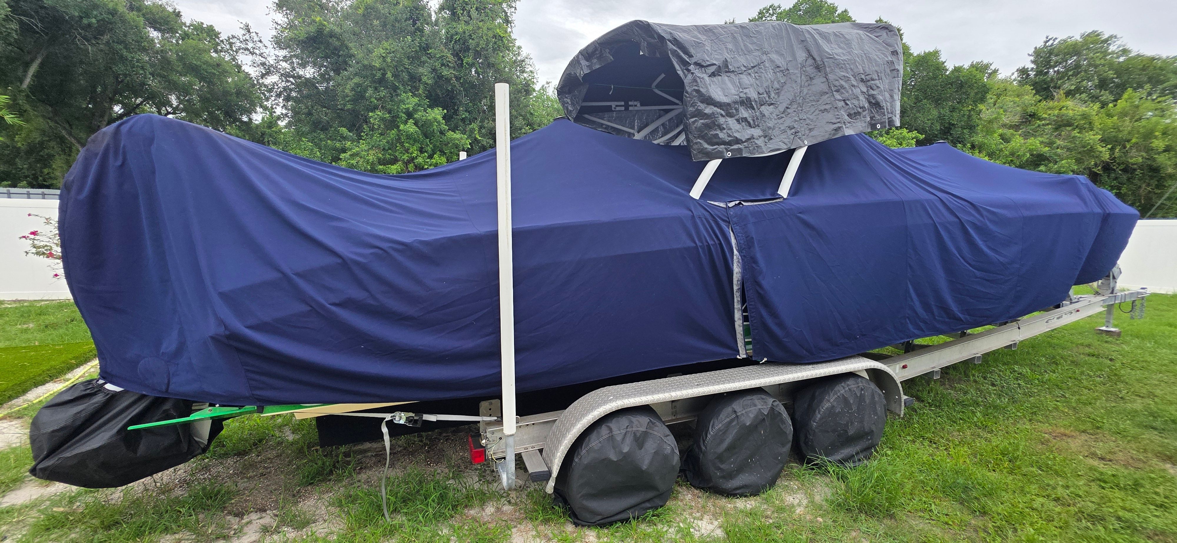Covered 2013 Renegade 32 FT boat on trailer outdoors.