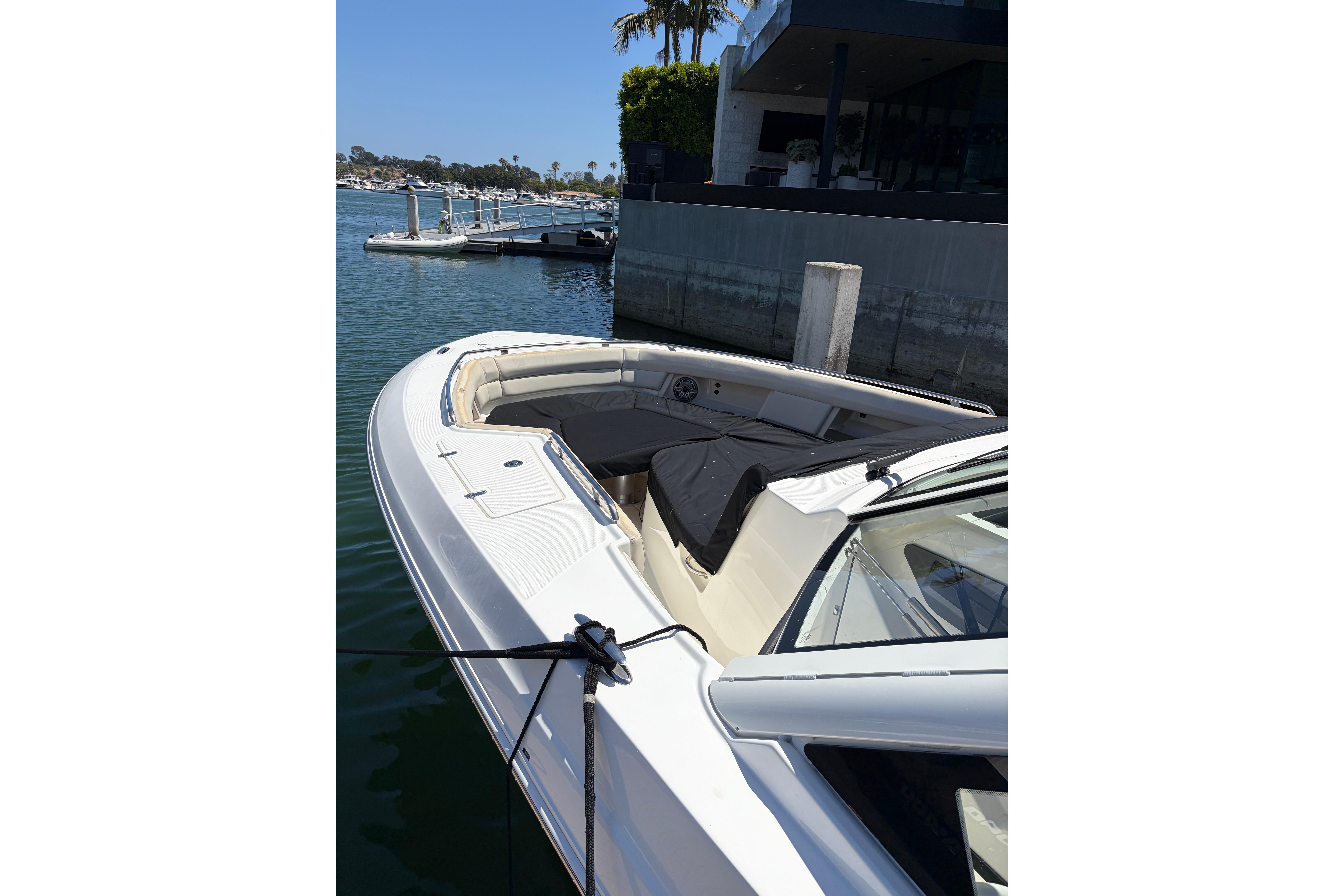 2020 Boston Whaler 380 Realm docked, showcasing sleek design and spacious seating area.