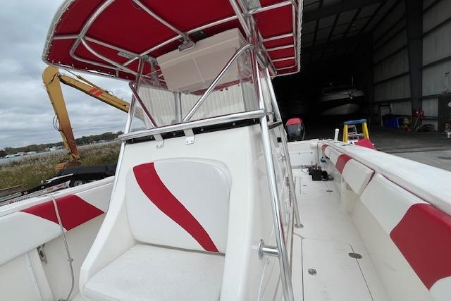 2001 Fountain 38 Center Console boat with red and white seating, docked in a marina.
