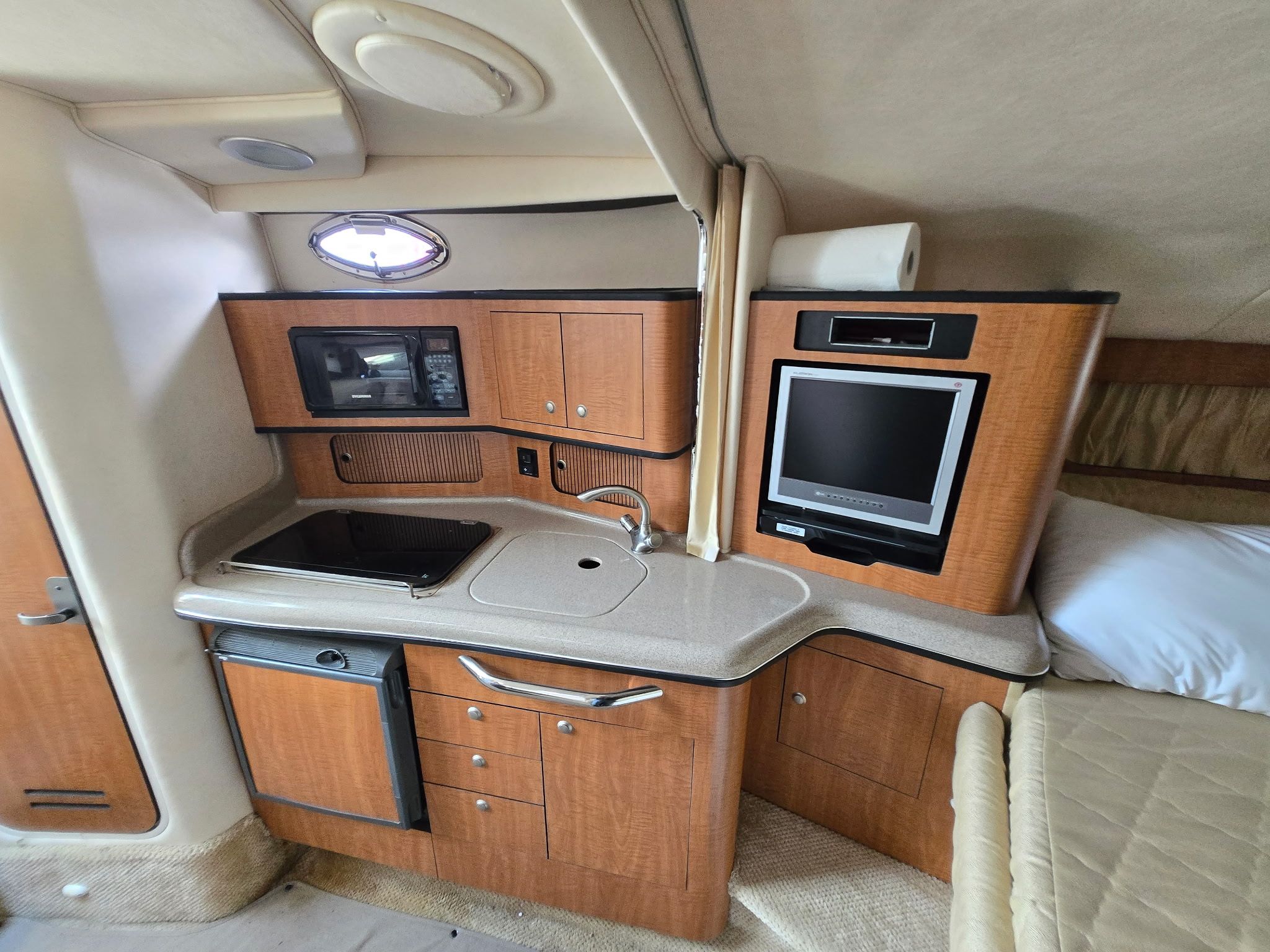 Interior of the 2006 Sea Ray 300 Sundancer with kitchenette and sleeping area.
