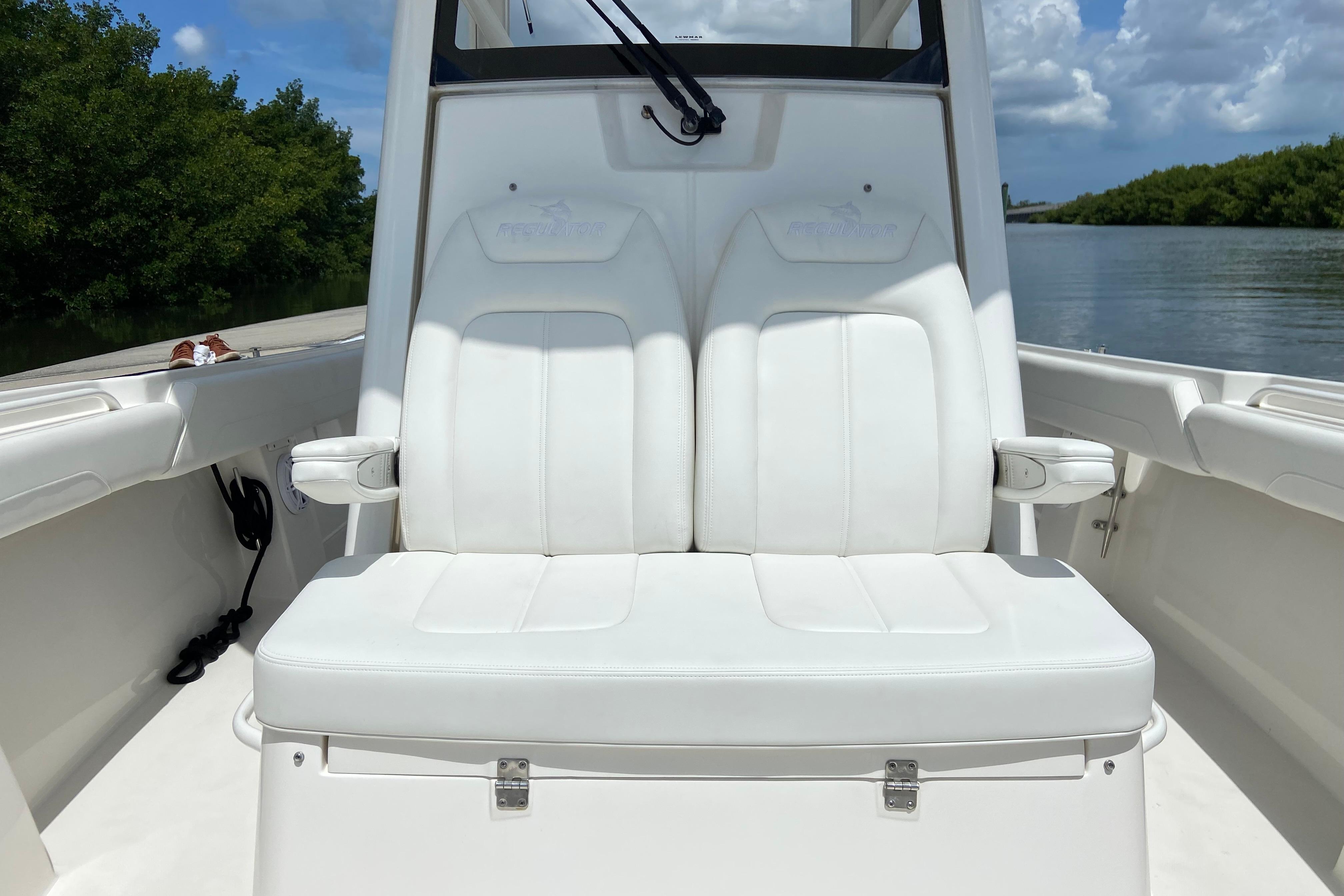 2021 Regulator 28 boat with white seating, docked on a sunny day.