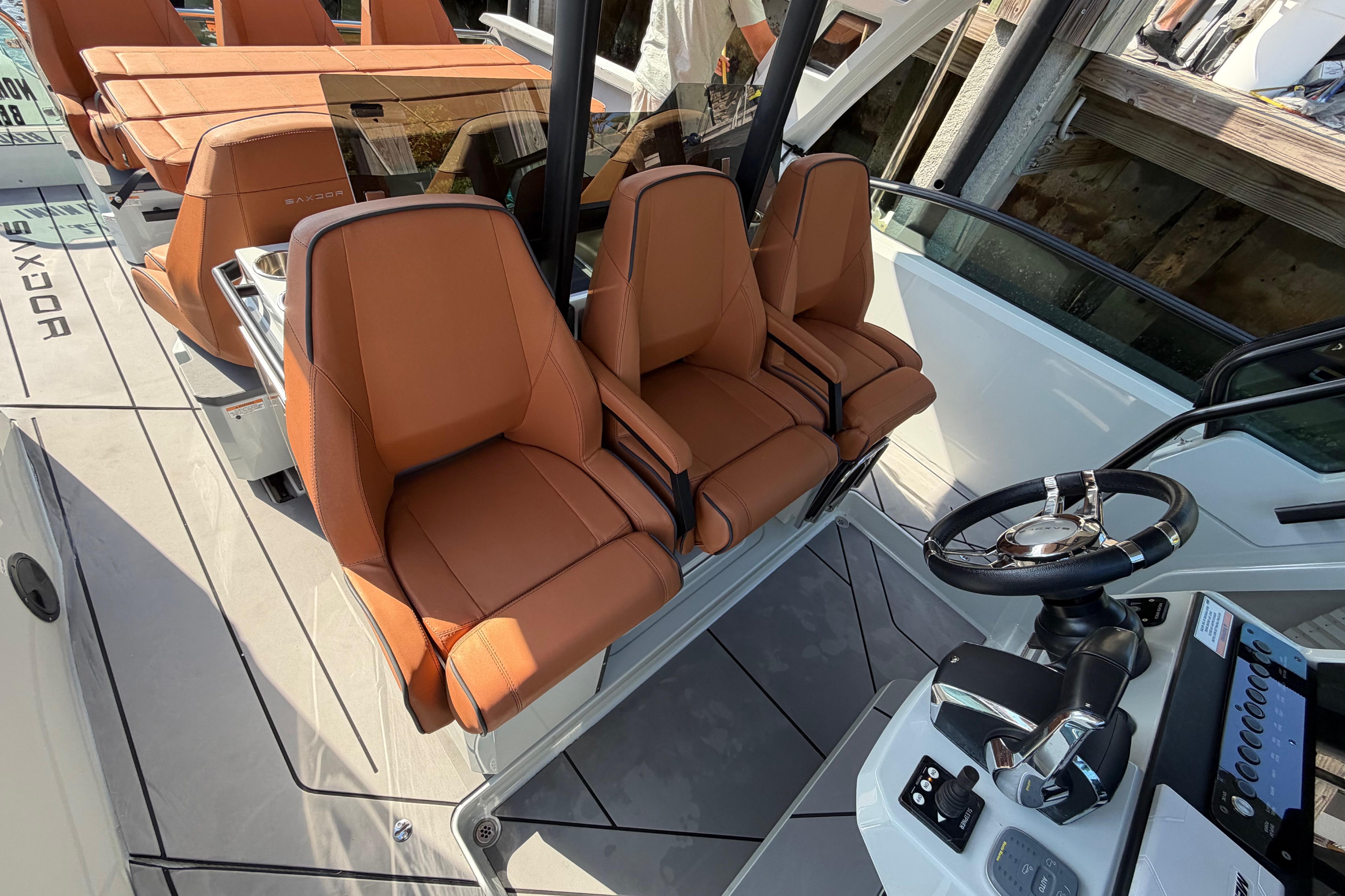 2024 Saxdor 320 GTO boat interior with brown leather seats and modern steering console.