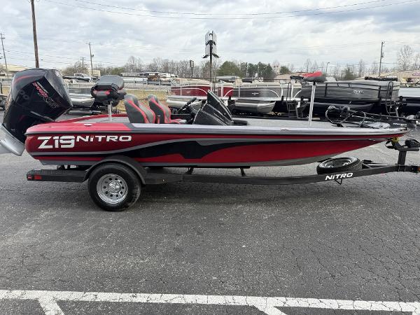 2025 Nitro Z19 boat, red and black, parked on a trailer in a lot.