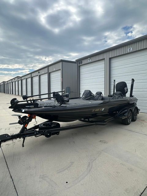 A 2023 Skeeter FXR21 Apex boat on a trailer in front of garages.