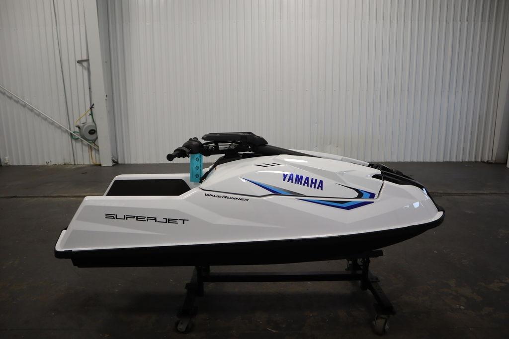 2025 Yamaha WaveRunner SuperJet in a showroom, side view, white and blue design.