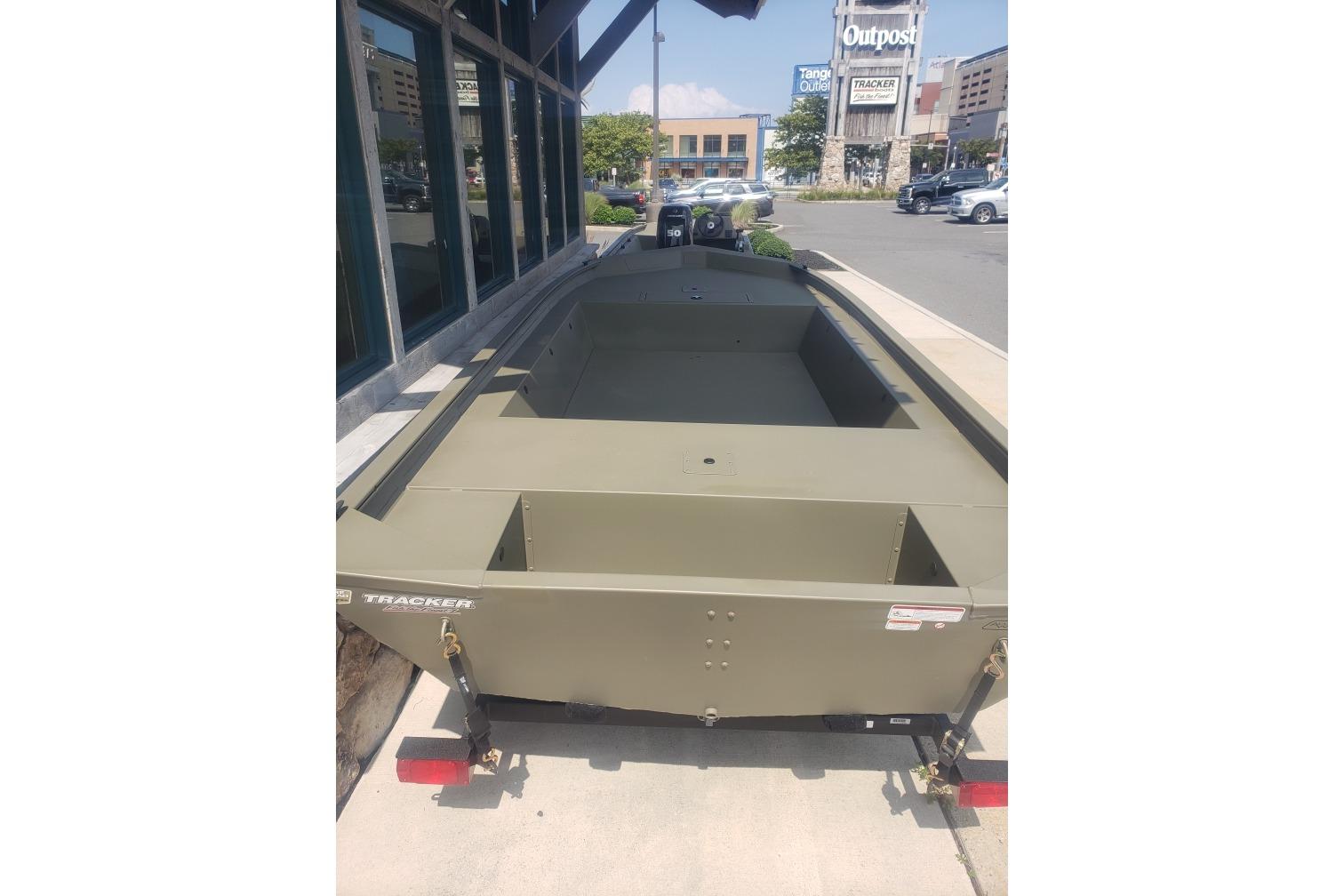 2026 Tracker Grizzly 1754 Utility boat parked outside a store on a sunny day.