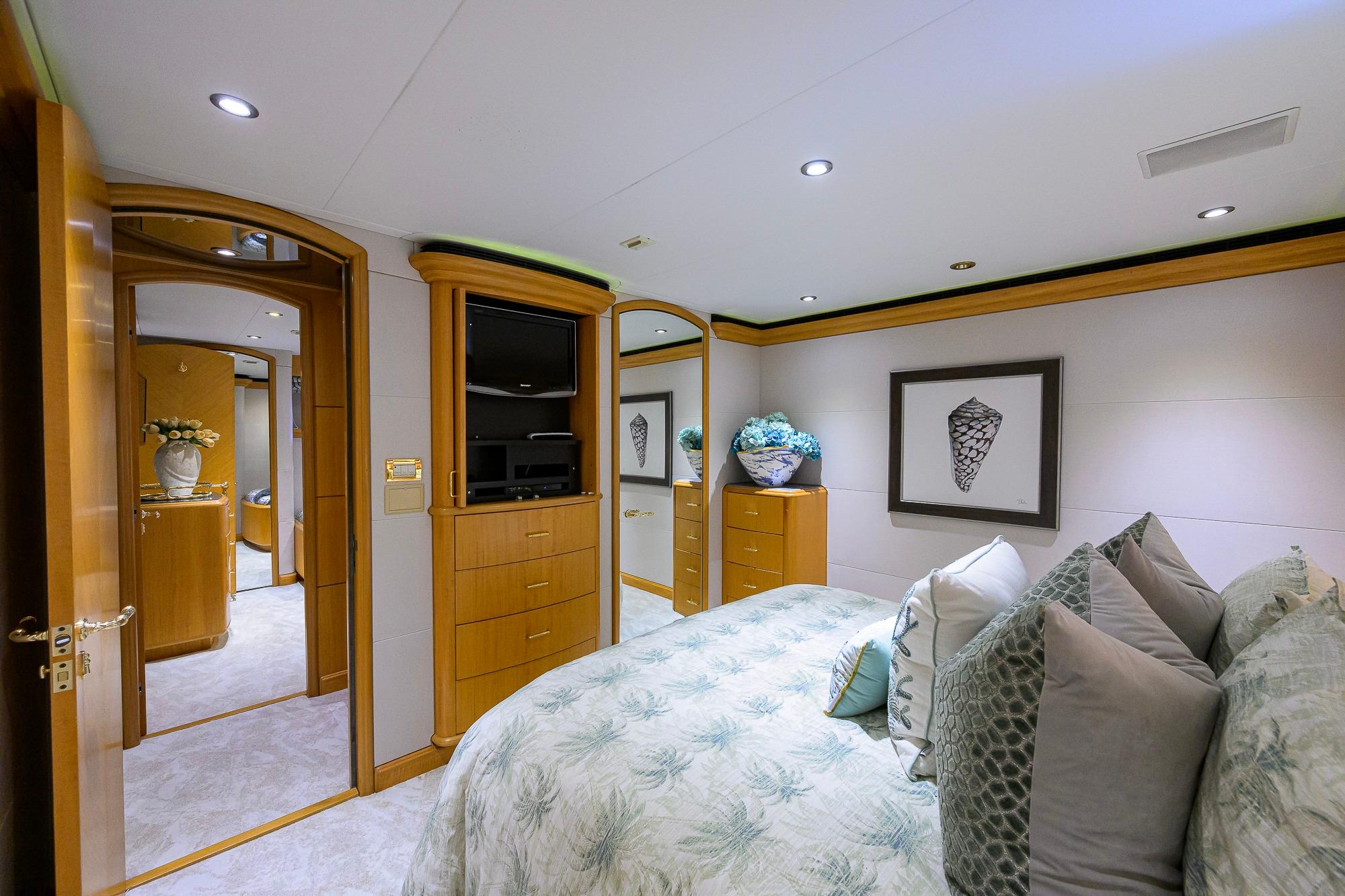 Luxurious bedroom interior on 2003 Cheoy Lee Trideck yacht, featuring elegant decor and cozy bedding.