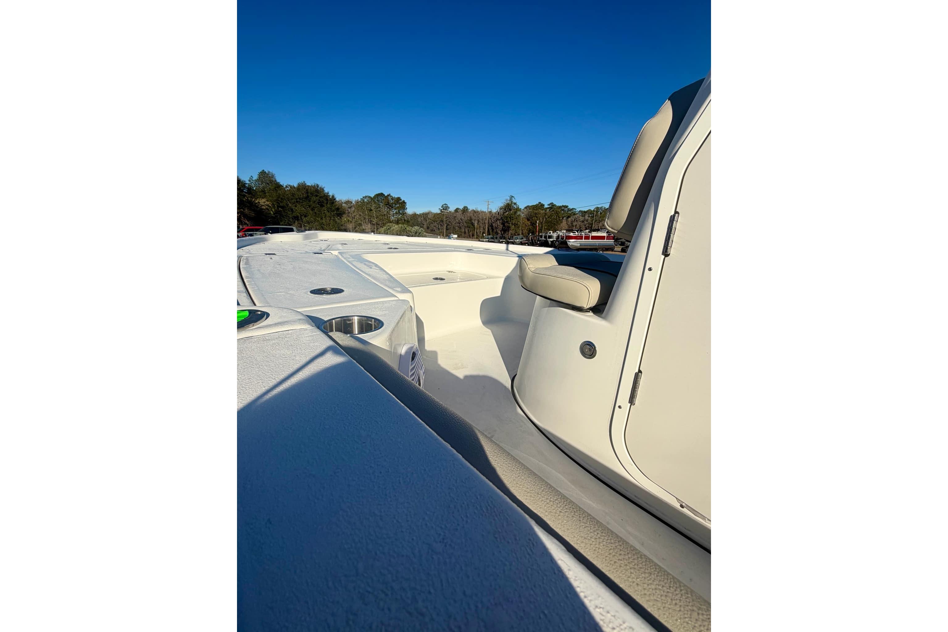 2026 Key West 210 Bay Reef boat interior with seating and cup holders under clear blue sky.