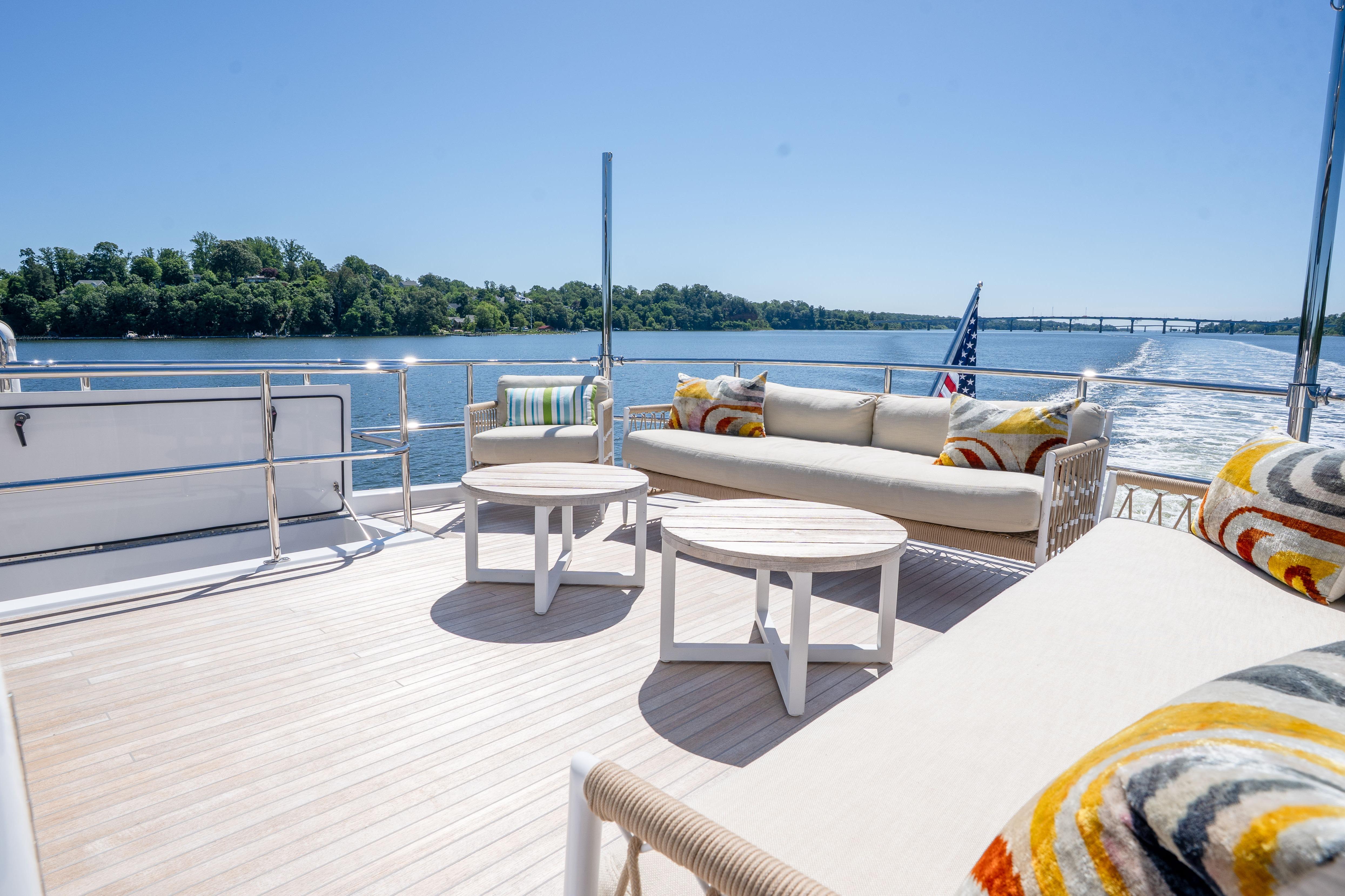 Luxurious deck of 2021 Hatteras M75 Panacera yacht with stylish seating and scenic water view.