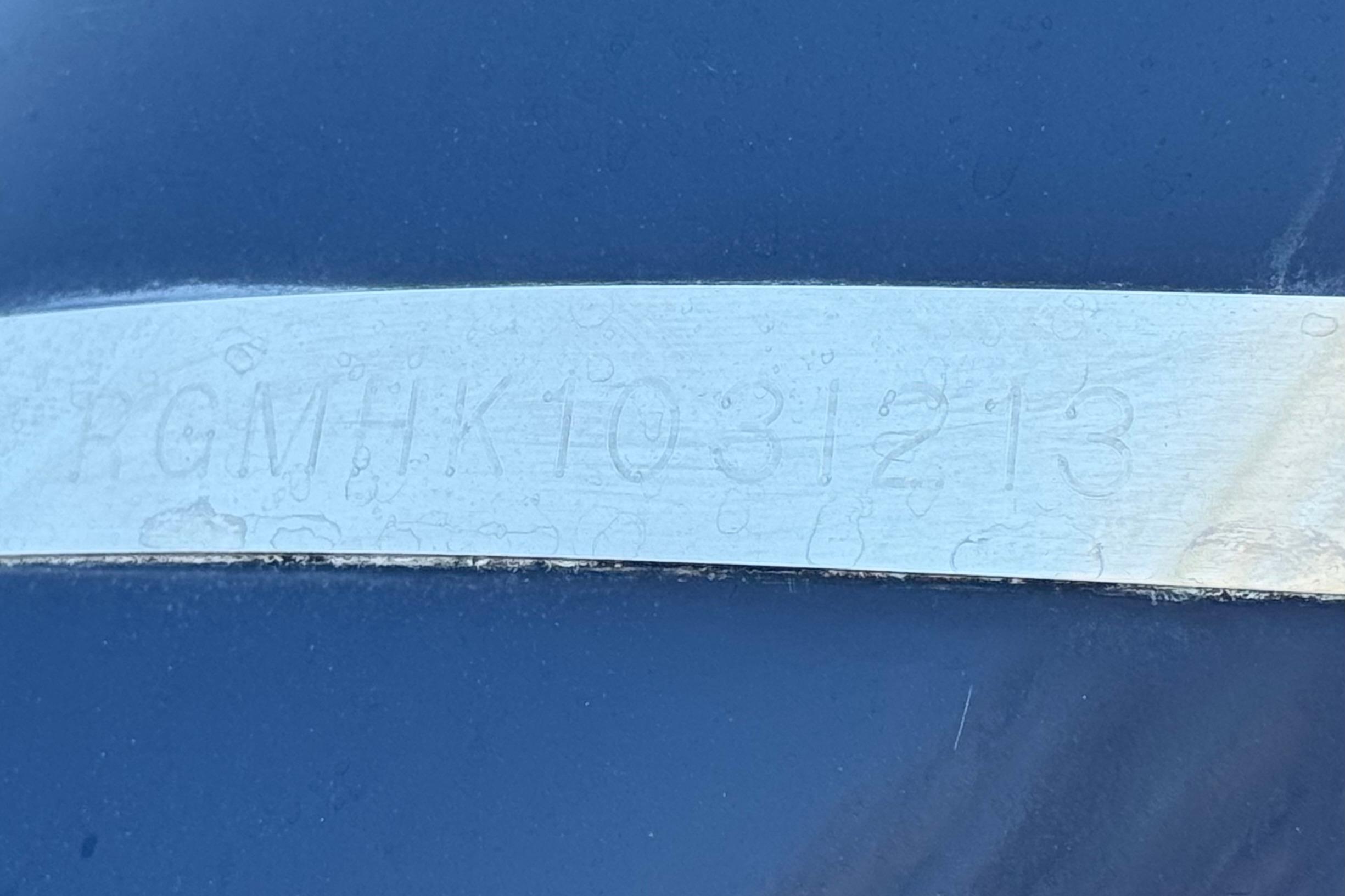 Close-up of a 2013 Regal 28 Express hull identification number on a blue surface.