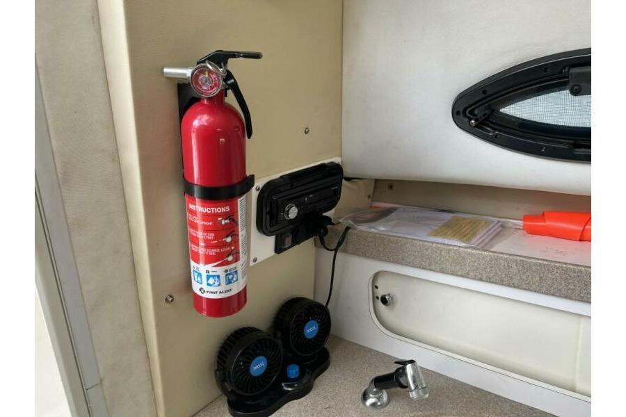 Interior of a 2006 Century 2400 Walk-Around boat with fire extinguisher and accessories.