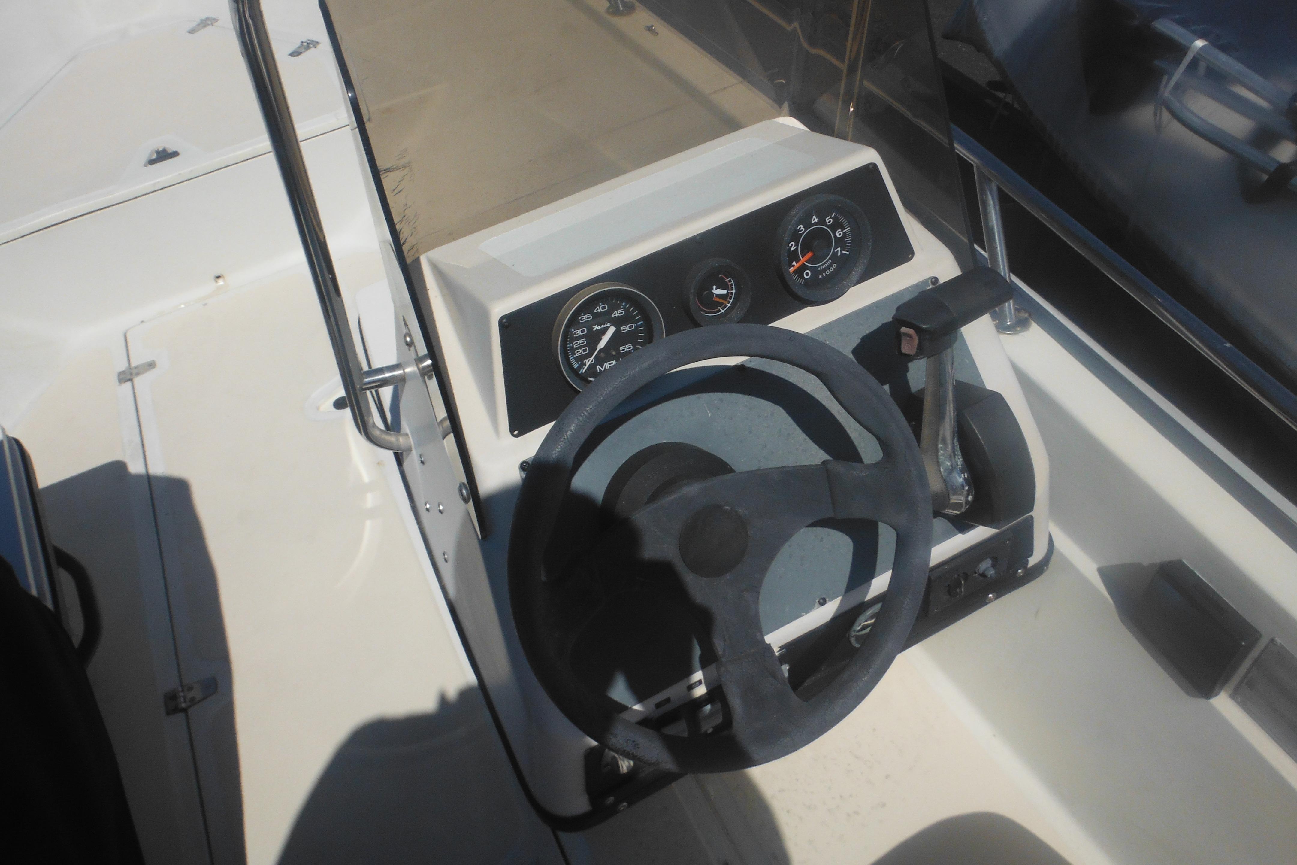 1991 Boston Whaler 16 SL boat dashboard with steering wheel and gauges.