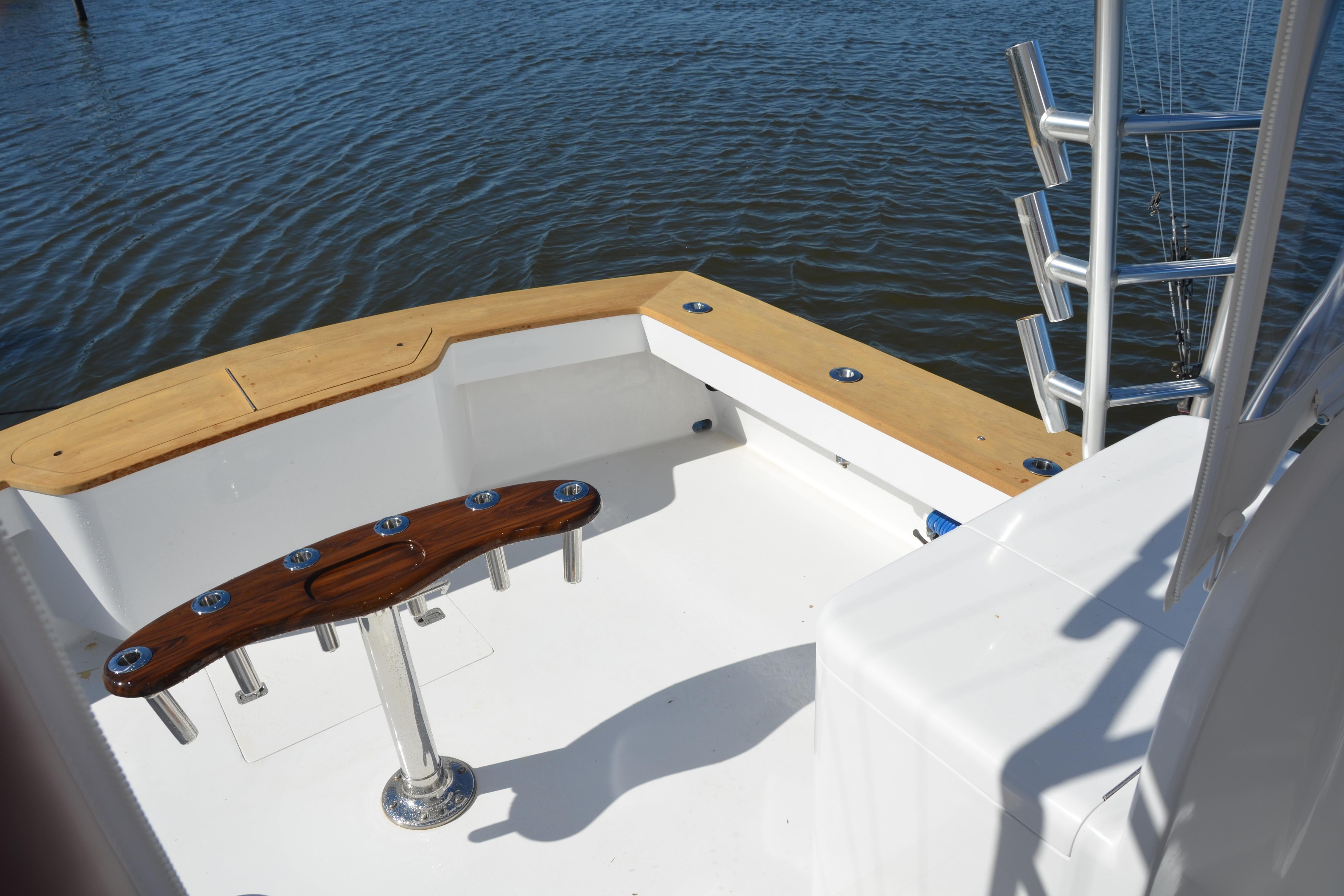 2006 Custom Carolina Heritage Express boat deck with rod holders, overlooking calm water.