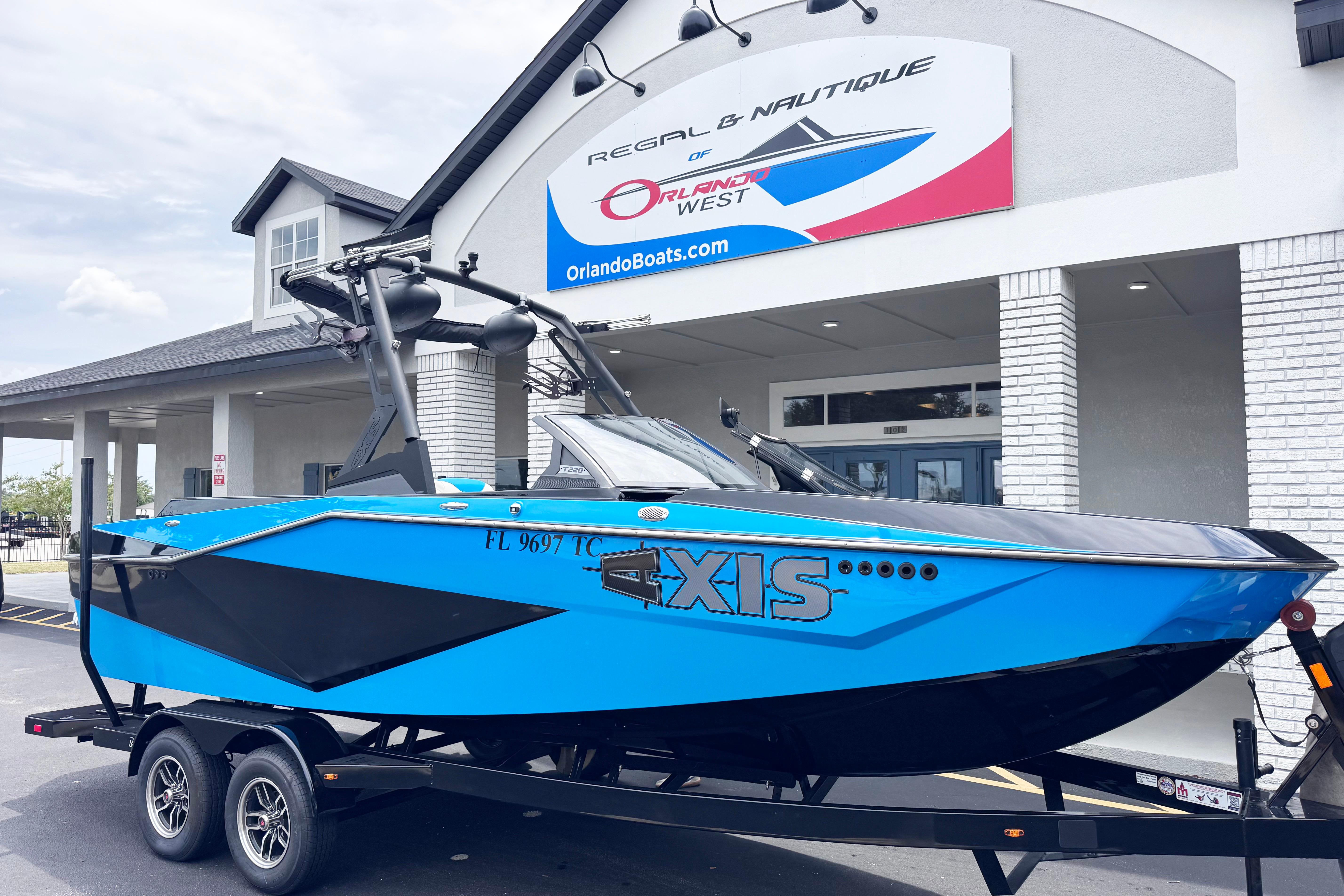 2022 Axis T220 boat in vibrant blue on trailer outside dealership.