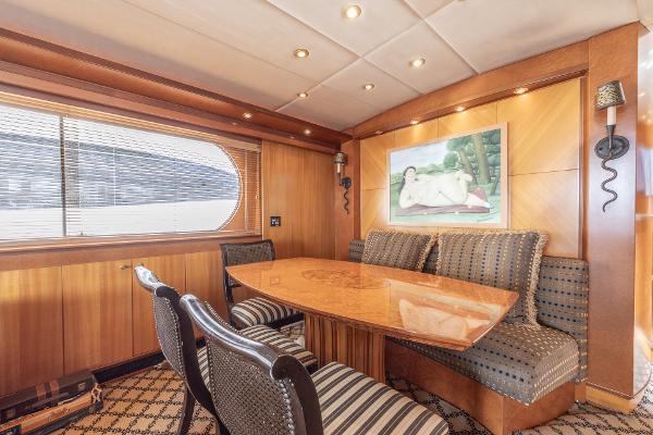 Luxurious dining area inside a 2001 Grand Harbour 76 yacht with elegant wood paneling.